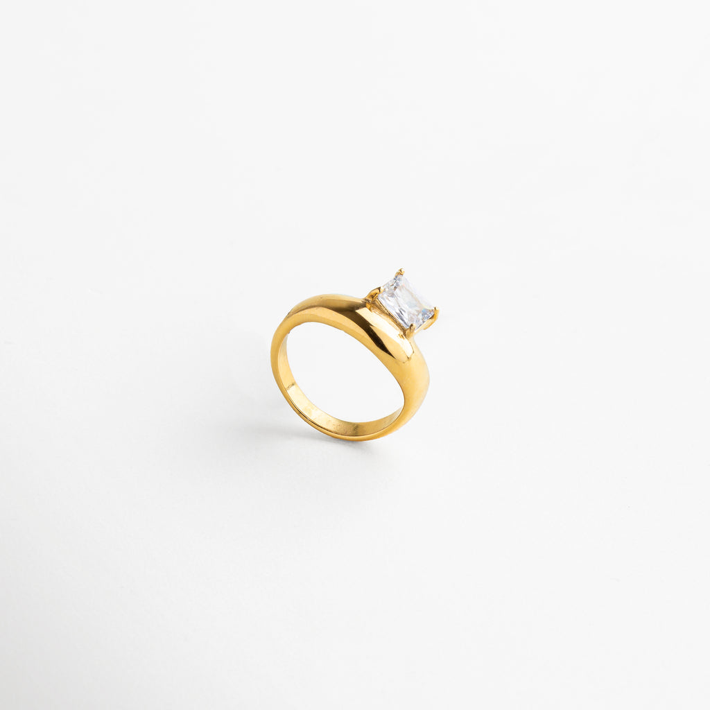 zirconia central corte ovalado de 0.7 x 0.9 cm, engaste delicado que realza el brillo, acabado pulido espejo en oro 18K, estructura del aro fina y elegante, diseño minimalista con toque de lujo