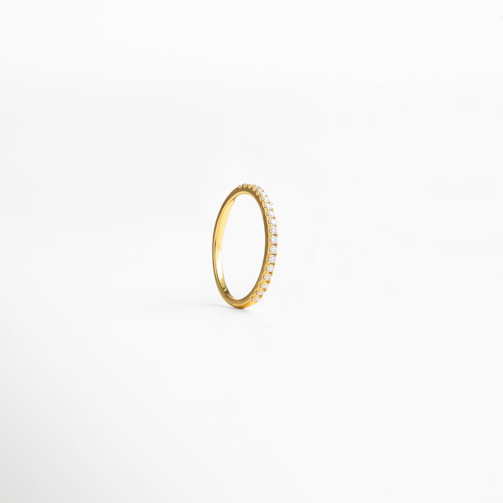 textura lisa y uniforme del metal, diseño minimalista atemporal, superficie que refleja la luz con suavidad, joya ligera y cómoda de llevar, detalle elegante y discreto