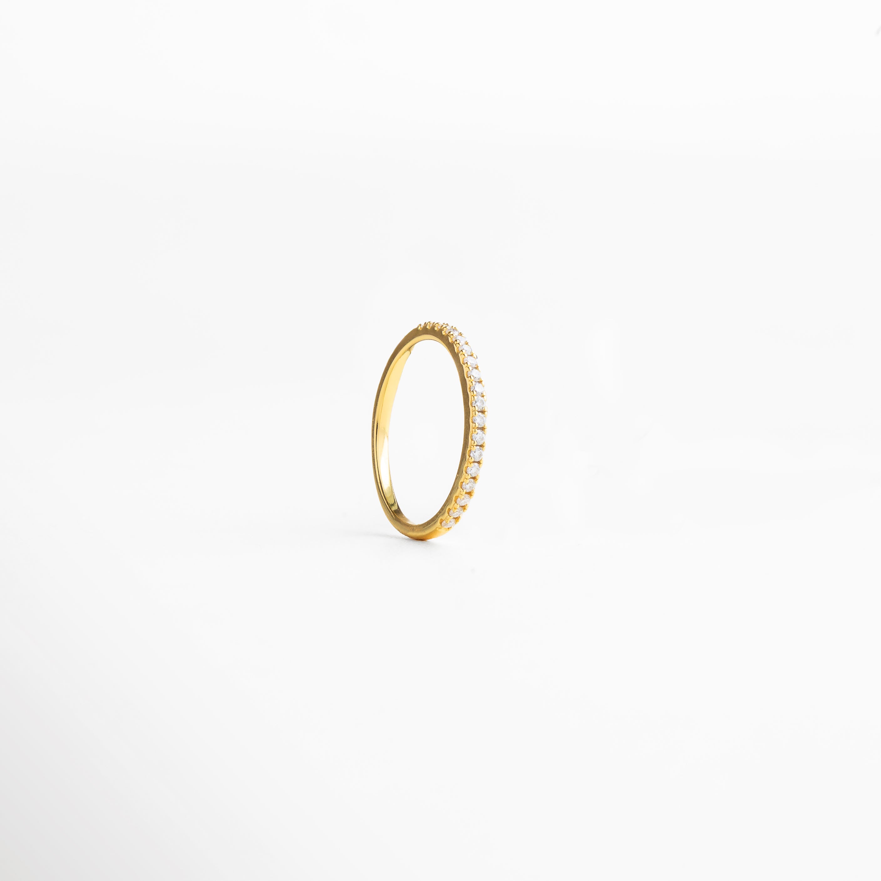 textura lisa y uniforme del metal, diseño minimalista atemporal, superficie que refleja la luz con suavidad, joya ligera y cómoda de llevar, detalle elegante y discreto