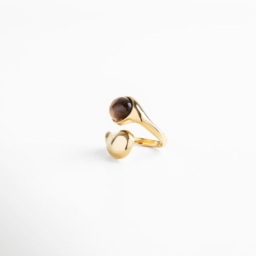 Anillo Akari Golden fabricado en acero inoxidable 316 con recubrimiento de oro 16K, piedra ojo de tigre incrustada y diseño orgánico de líneas curvas, joya contemporánea con acabado pulido que combina fuerza y elegancia.