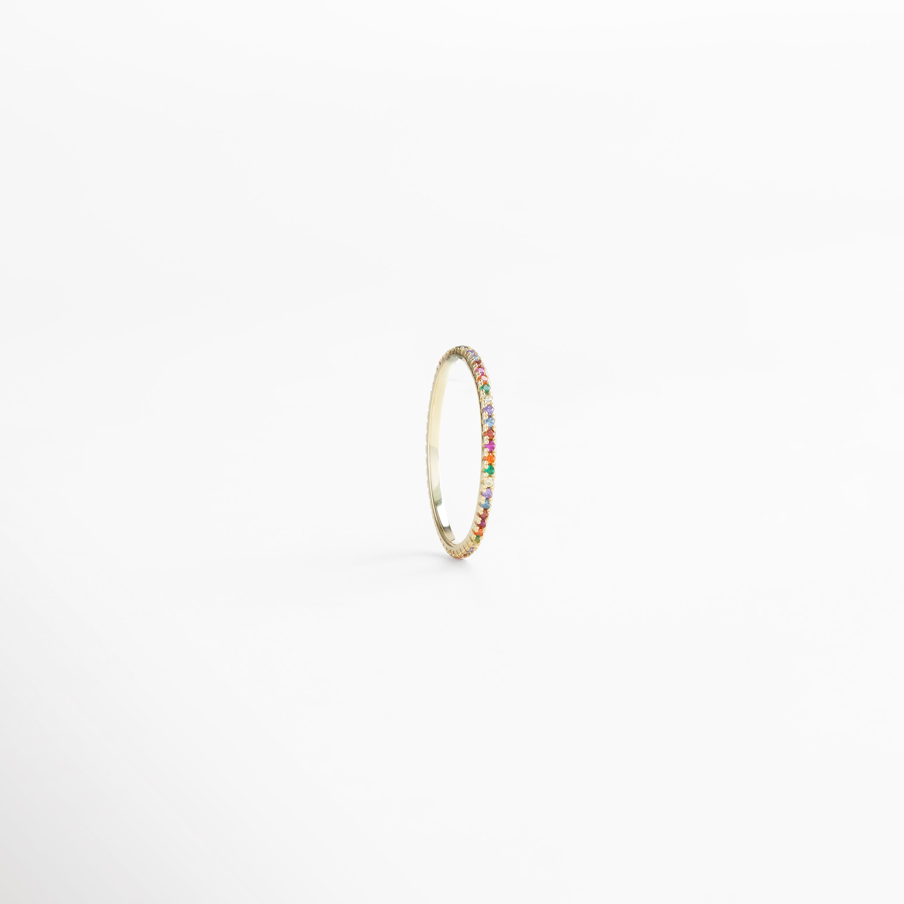 Vista lateral del anillo de plata 925 con baño de oro 18K e incrustaciones de zirconias brillantes multicolor, diseño moderno y versátil con diámetro interno de 2 cm, joya femenina ideal para complementar cualquier look.