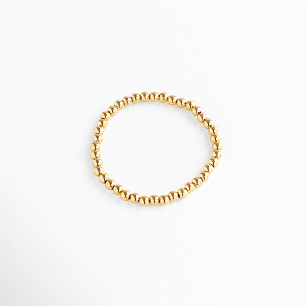 Pulsera de cuentas doradas medianas, diseño elástico y elegante, Pulsera dorada minimalista con esferas medianas, estilo moderno y versátil.