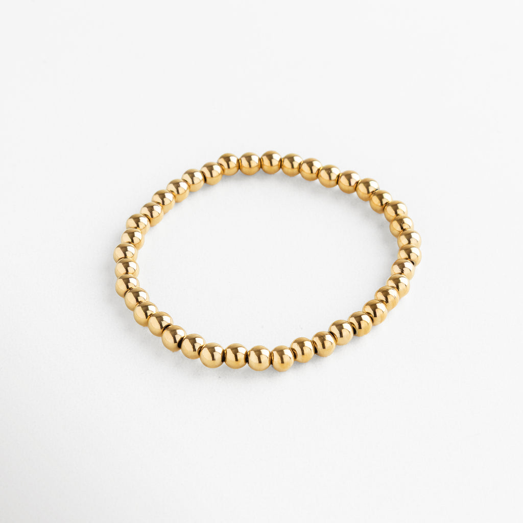 Set de pulseras doradas con cuentas en varios tamaños, incluye pulsera mediana, Conjunto de pulseras doradas apilables, diseño minimalista con cuentas medianas.