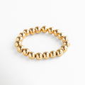 Pulsera elástica de cuentas grandes en acero inoxidable con baño de oro 18K, diseño minimalista y versátil ideal para usar sola o en capas.