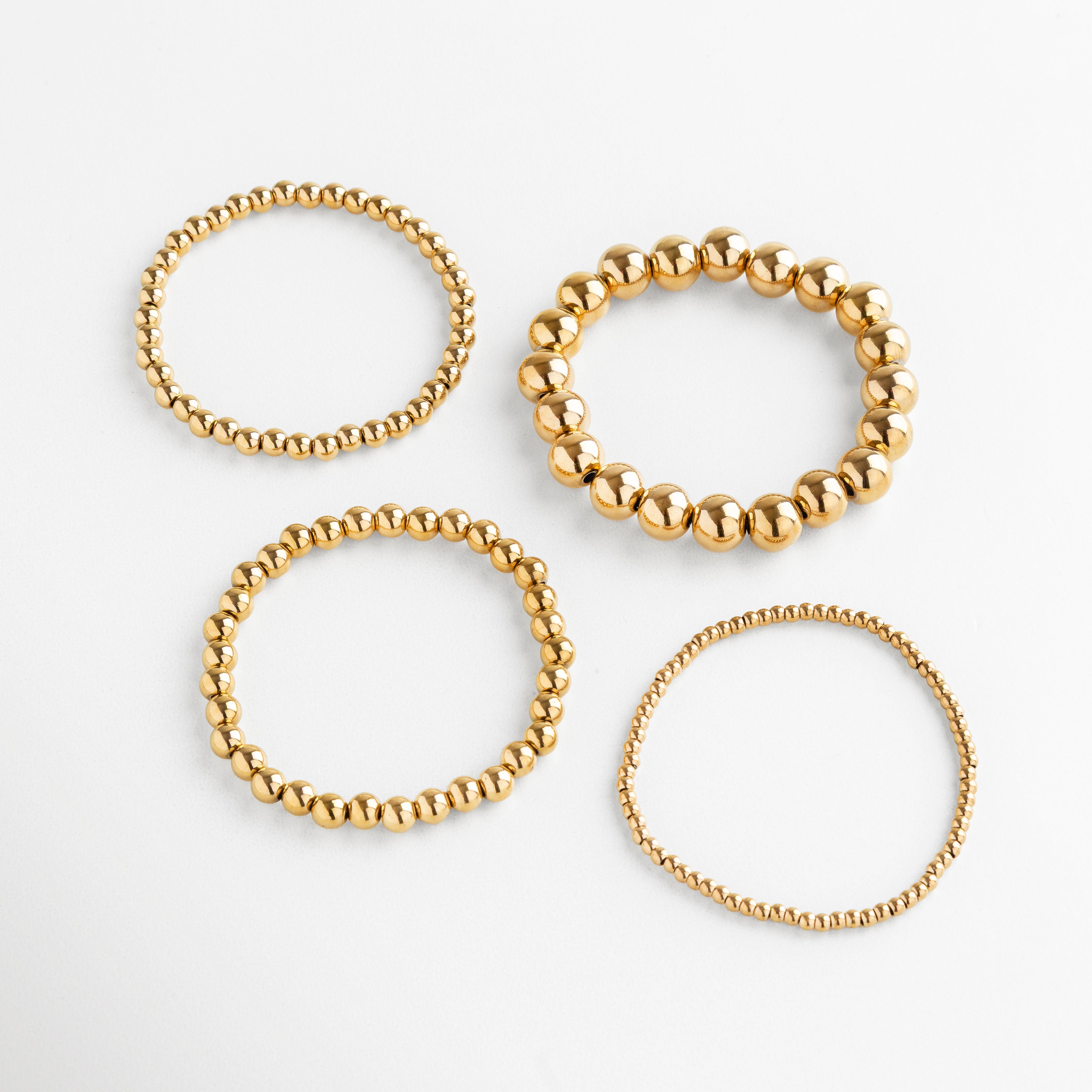 Set de pulseras doradas de cuentas redondas en diferentes tamaños, estilo apilable, Conjunto de pulseras doradas modernas y minimalistas, accesorio versátil.