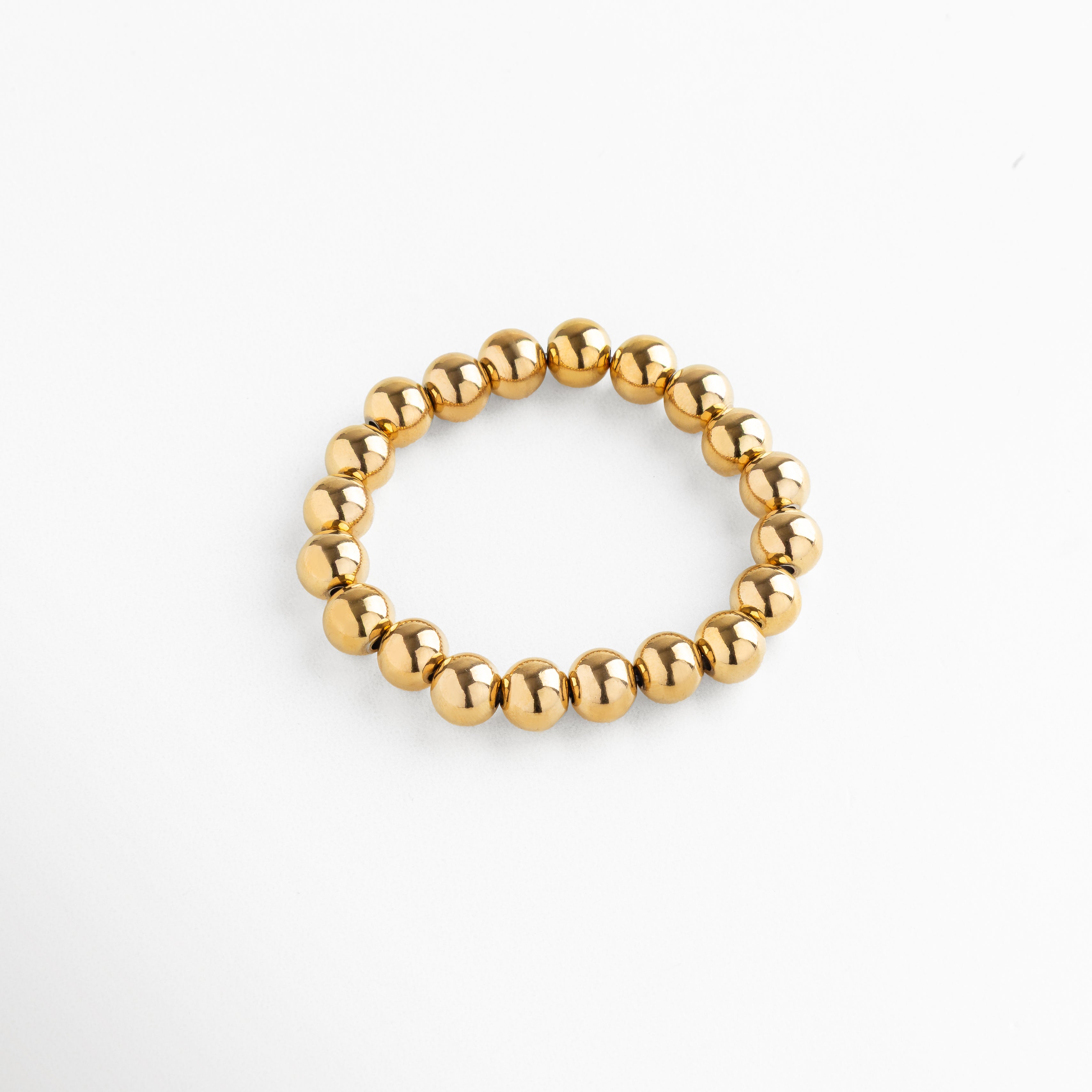 Pulsera elástica de cuentas metálicas doradas, diseño clásico y sofisticado, pieza versátil para un estilo elegante y effortless.