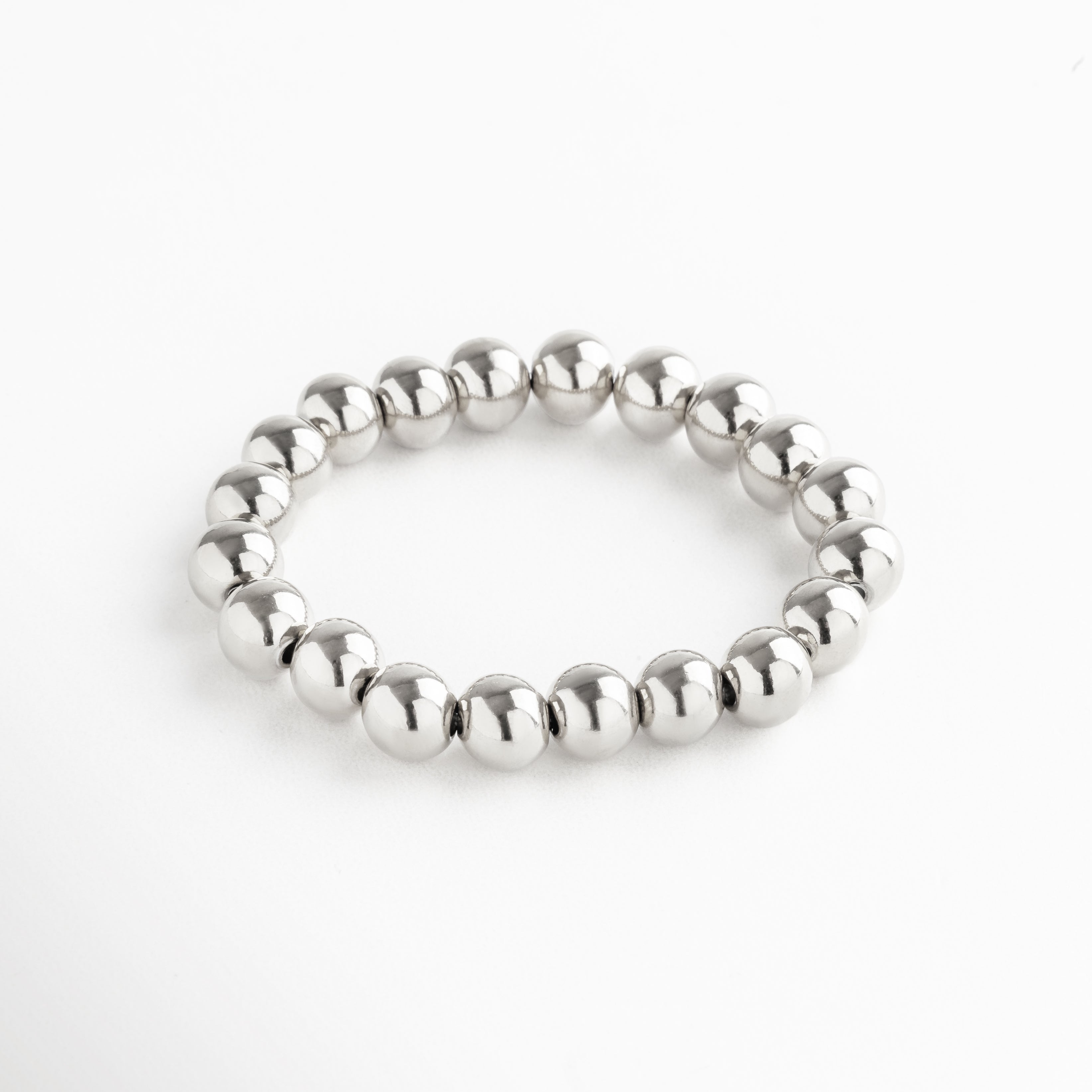 Pulsera elástica de cuentas grandes en acero inoxidable con baño de oro blanco 18K, diseño minimalista y versátil ideal para usar sola o en capas.