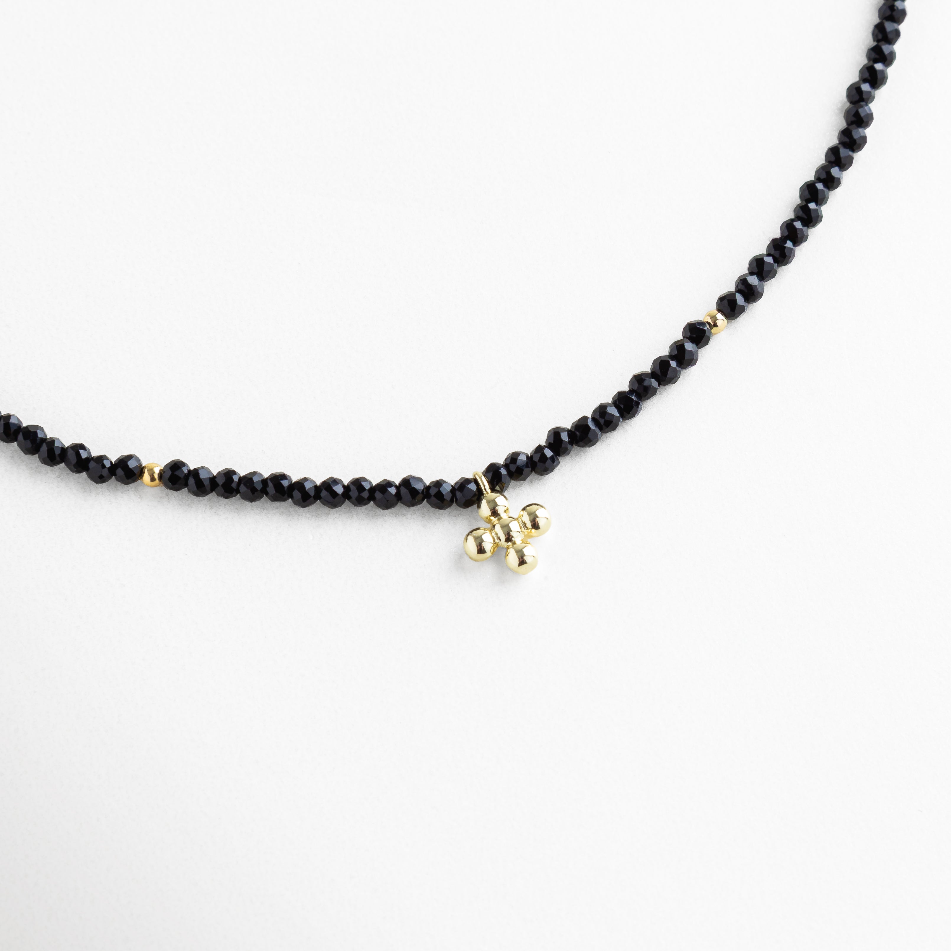 Collar de cuentas negras con dije dorado minimalista, cristal sintético y baño en oro 18K, diseño elegante y moderno para uso diario o de noche.