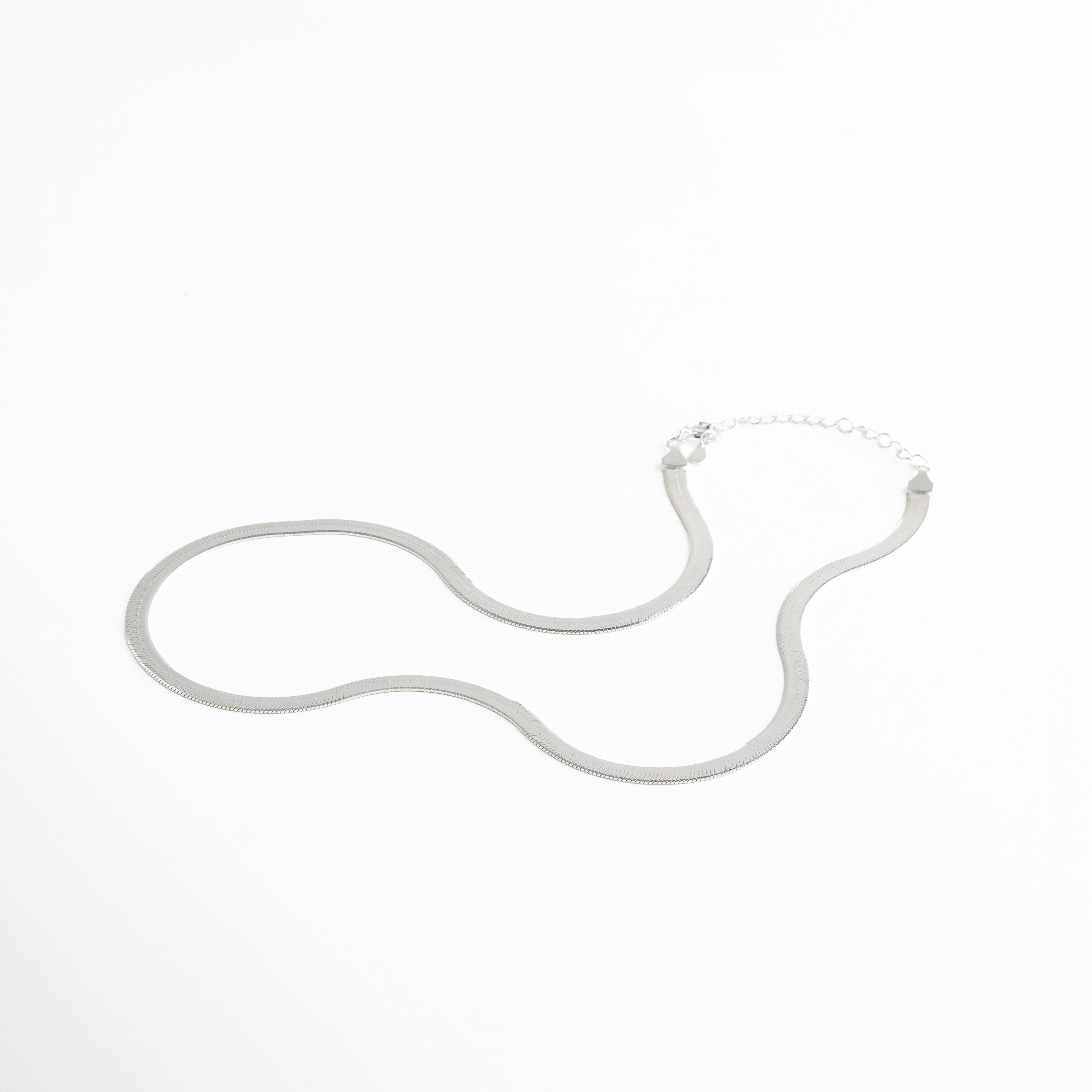 Collar Pressed Silver Aída visto de perfil, mostrando su grosor delgado y caída uniforme. Vista lateral del collar plateado, resaltando su acabado planchado y líneas limpias. Perfil del collar minimalista en plata, diseño elegante y discreto. Detalle lateral del collar Pressed Silver Aída, mostrando su estructura ligera y pulida. Collar plateado visto desde un ángulo lateral, diseño versátil y acabado reflectivo.