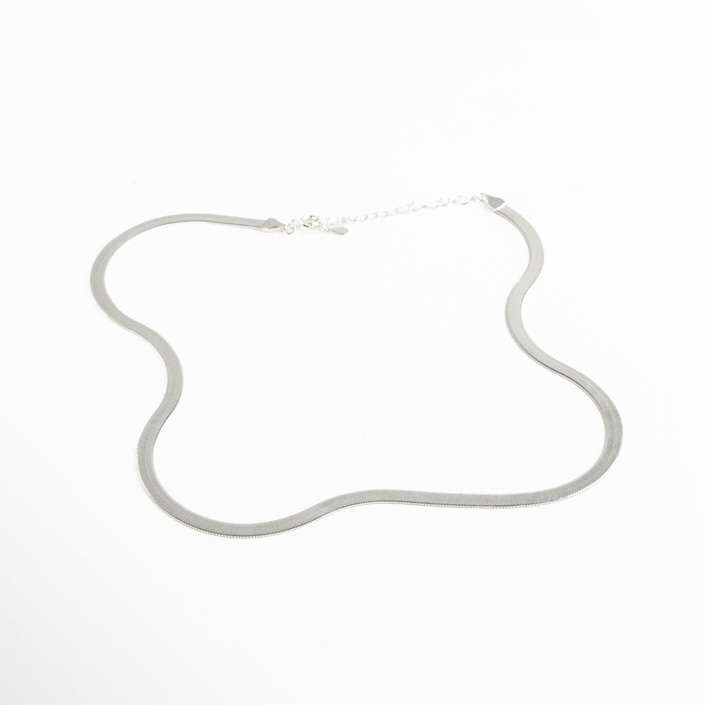 Collar Pressed Silver Aída visto de perfil, mostrando su grosor delgado y caída uniforme. Vista lateral del collar plateado, resaltando su acabado planchado y líneas limpias. Perfil del collar minimalista en plata, diseño elegante y discreto. Detalle lateral del collar Pressed Silver Aída, mostrando su estructura ligera y pulida. Collar plateado visto desde un ángulo lateral, diseño versátil y acabado reflectivo.