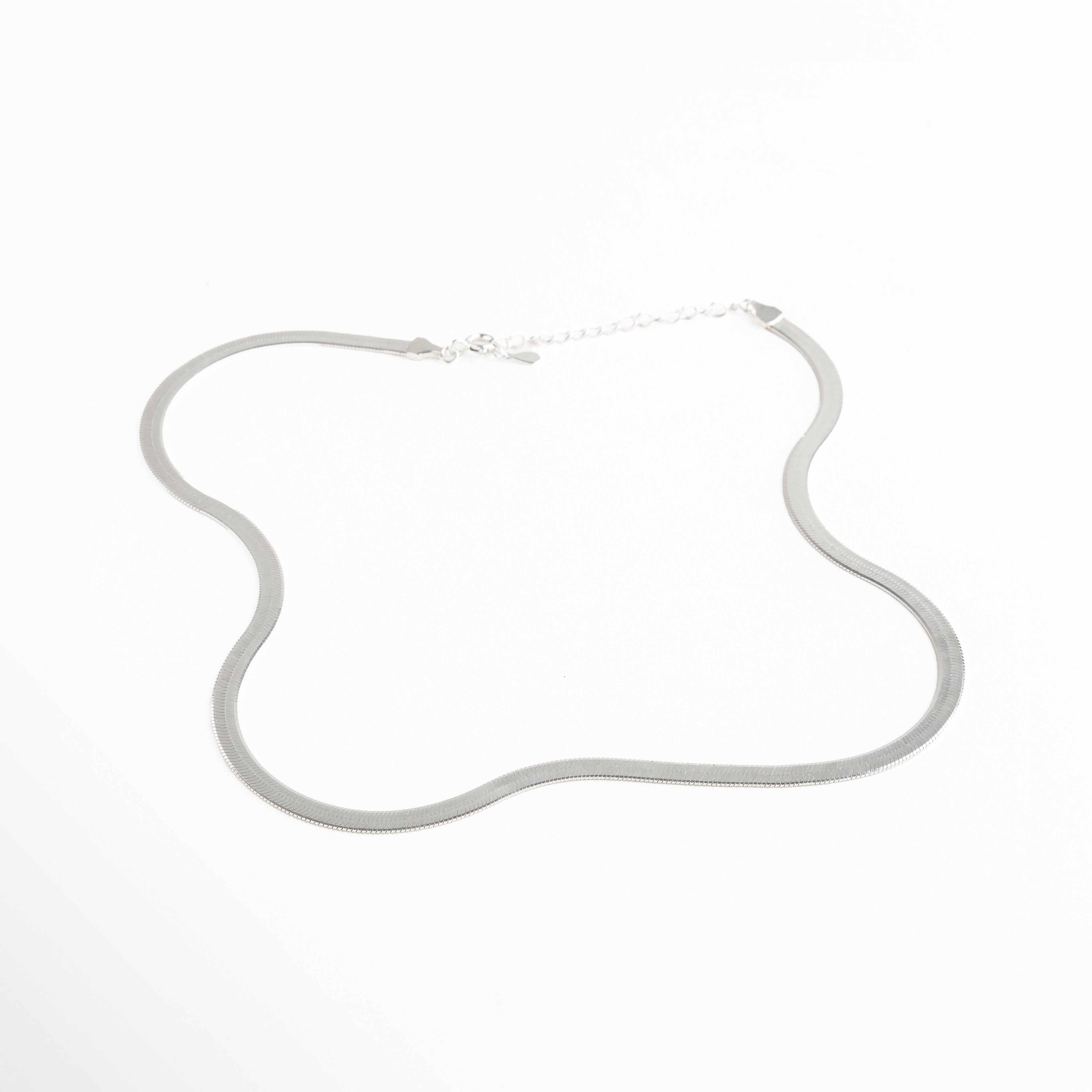 Collar Pressed Silver Aída visto de perfil, mostrando su grosor delgado y caída uniforme. Vista lateral del collar plateado, resaltando su acabado planchado y líneas limpias. Perfil del collar minimalista en plata, diseño elegante y discreto. Detalle lateral del collar Pressed Silver Aída, mostrando su estructura ligera y pulida. Collar plateado visto desde un ángulo lateral, diseño versátil y acabado reflectivo.