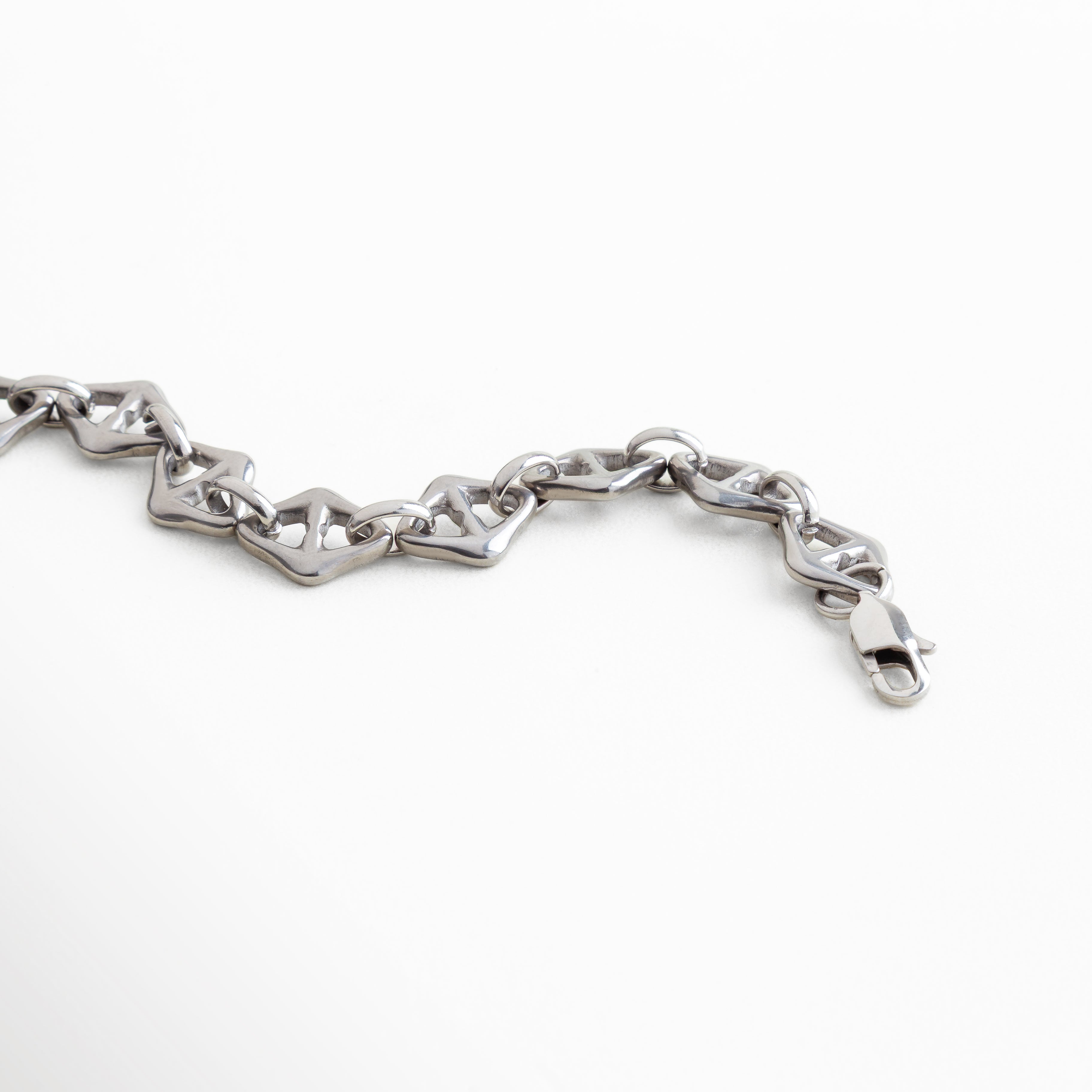 acercamiento al diseño geométrico de la pulsera, textura pulida y líneas definidas, acabado brillante en oro blanco 18K, estilo contemporáneo y refinado