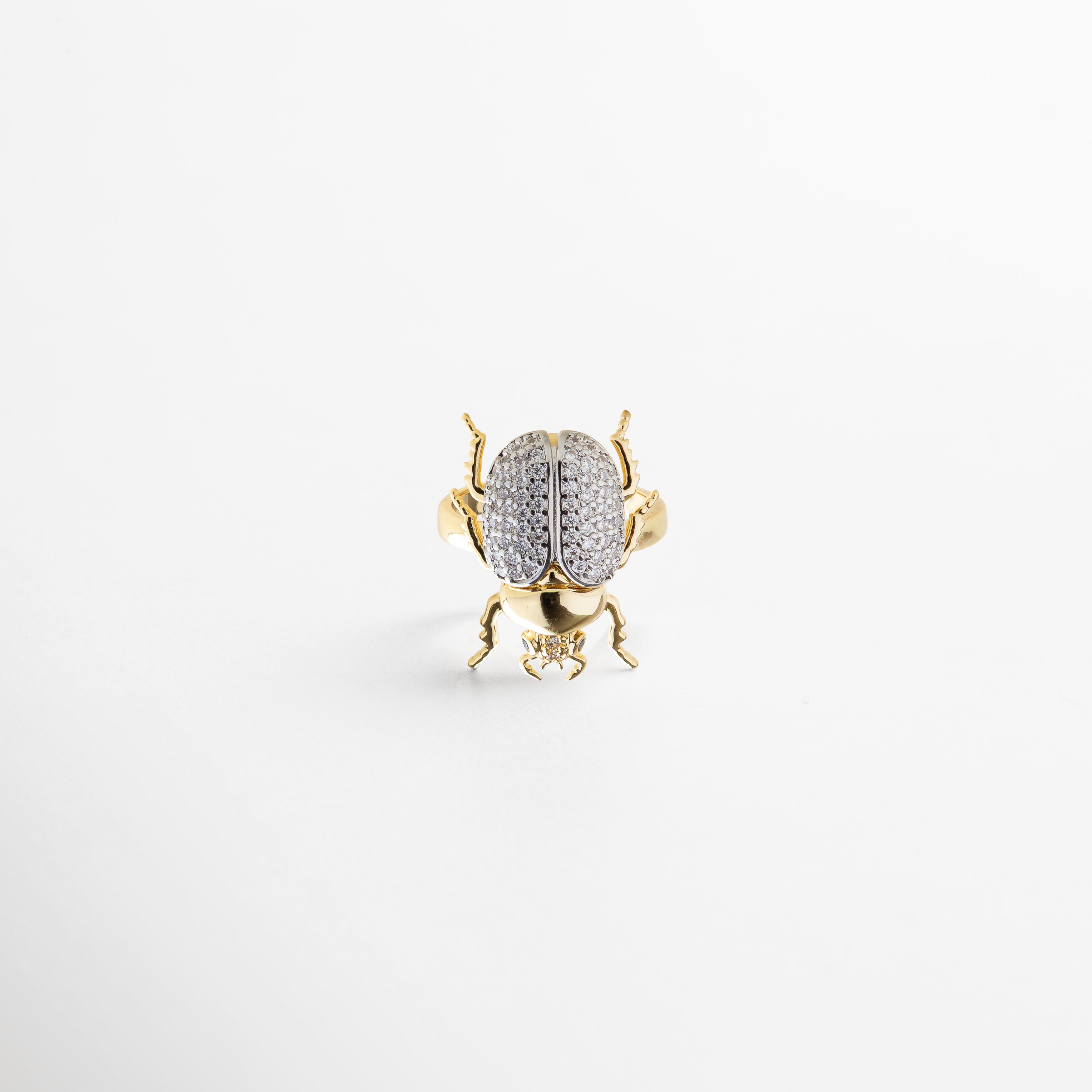 combinación de diseño artístico y minimalismo, zirconias que capturan la luz, proporción equilibrada entre escarabajo y aro, detalle sofisticado y llamativo, pieza versátil para distintos estilos
