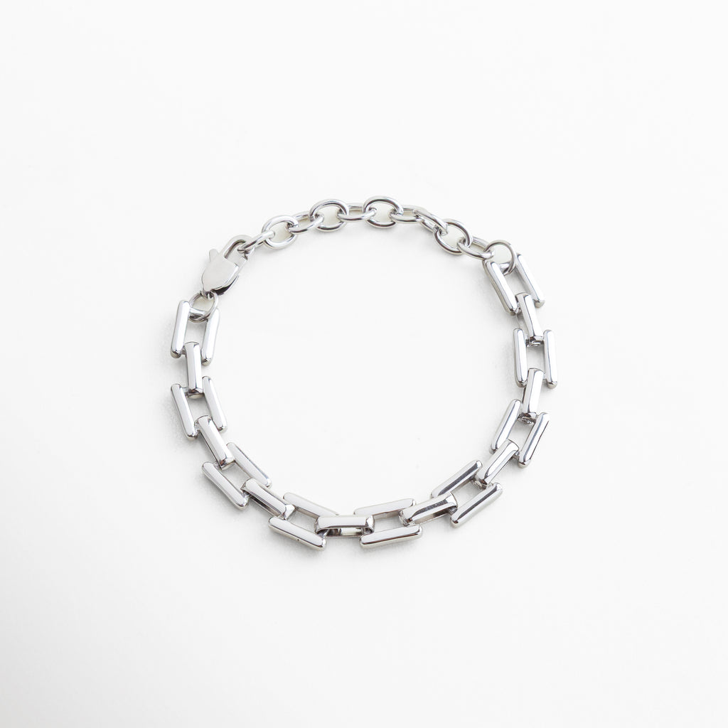 Pulsera de eslabones rectangulares en acero inoxidable con baño en oro blanco 18K, diseño moderno y versátil para un estilo atemporal y sofisticado.