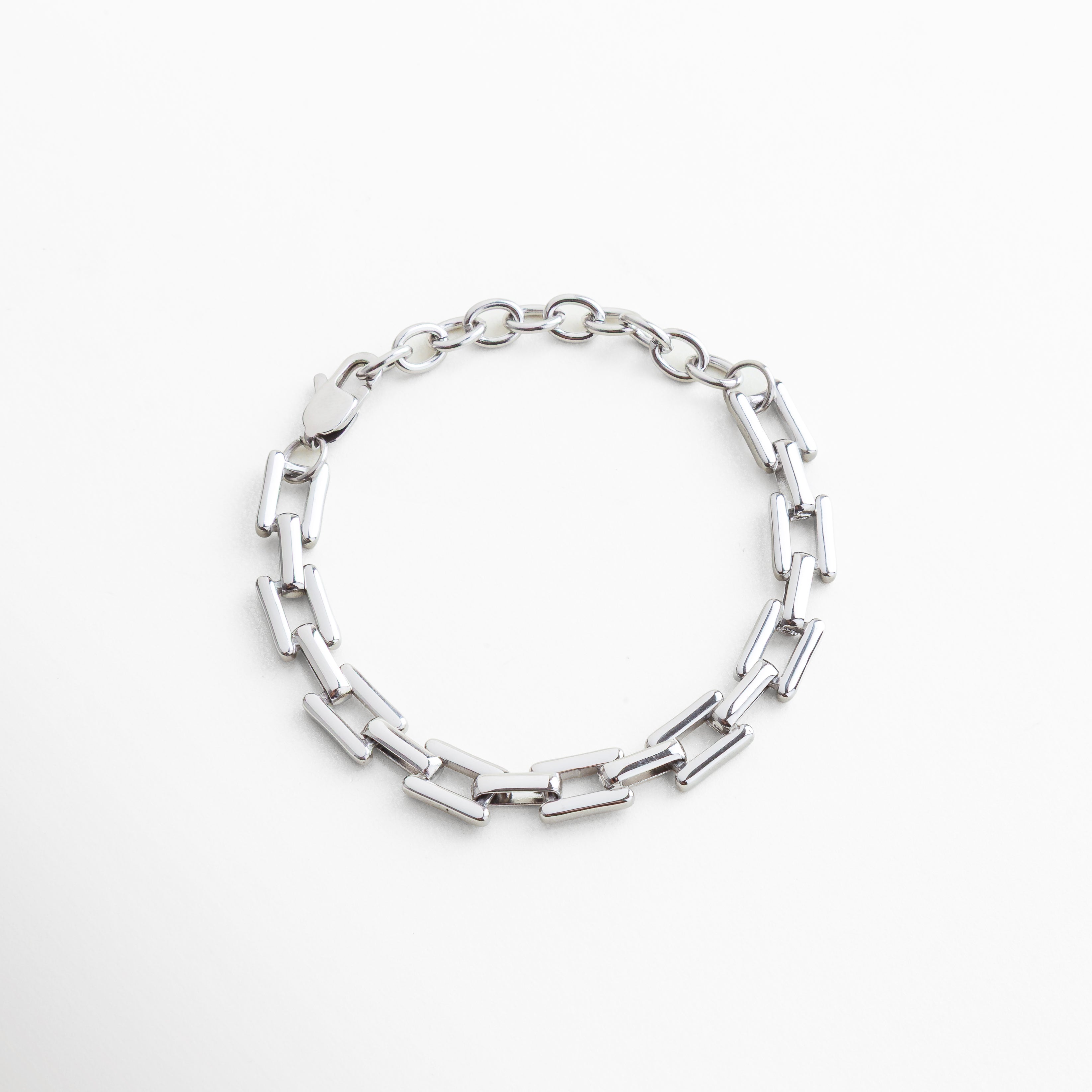 Pulsera de eslabones rectangulares en acero inoxidable con baño en oro blanco 18K, diseño moderno y versátil para un estilo atemporal y sofisticado.