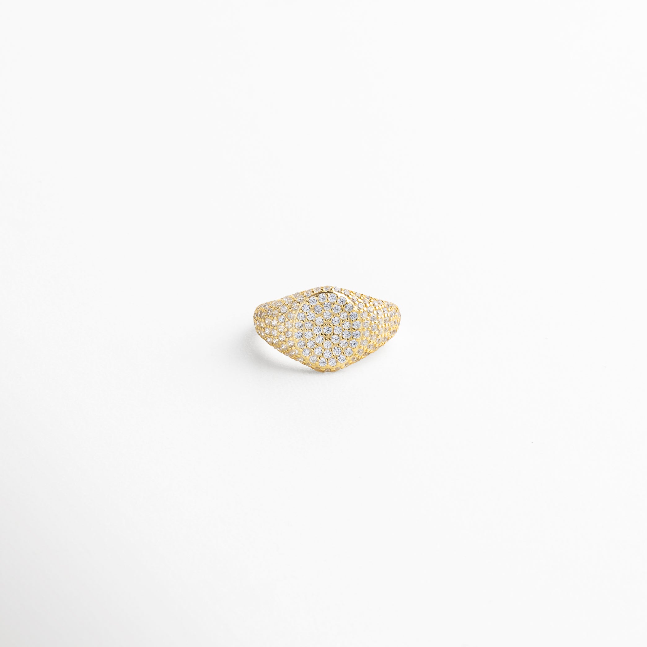 Vista superior del Anillo Golden Idriss dorado, con detalles en zirconia sobre superficie brillante de 2.5 cm. Toma cenital del anillo con incrustaciones brillantes en dorado, destacando su forma elegante y delicada. Anillo dorado visto desde arriba, con zirconias perfectamente distribuidas en un diseño refinado. Perspectiva superior del anillo de plata 925 con baño dorado e incrustaciones que capturan la luz. Vista desde arriba del Anillo Golden Idriss, resaltando su silueta alargada y bril