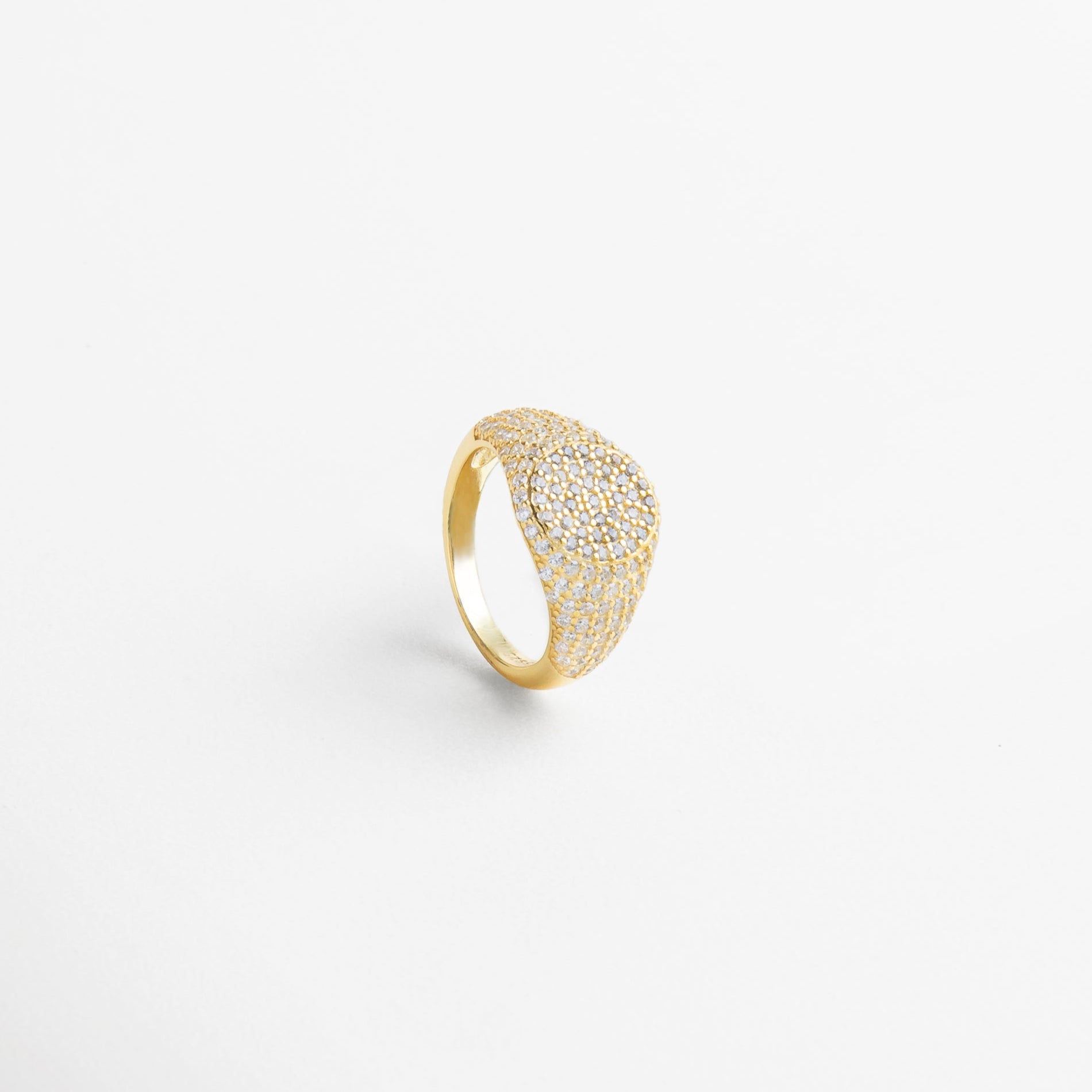 Anillo Golden Idriss dorado visto desde el frente, con incrustaciones de zirconia que reflejan la luz con elegancia. Vista frontal del anillo dorado con detalles brillantes, diseño sofisticado y acabado en plata 925. Anillo dorado con zirconias incrustadas visto de frente, ideal para elevar looks diarios con un toque de lujo. Primer plano del Anillo Golden Idriss dorado, destacando su forma estilizada y detalles luminoso Frontal del anillo con incrustaciones finas en tono dorado, combinaci