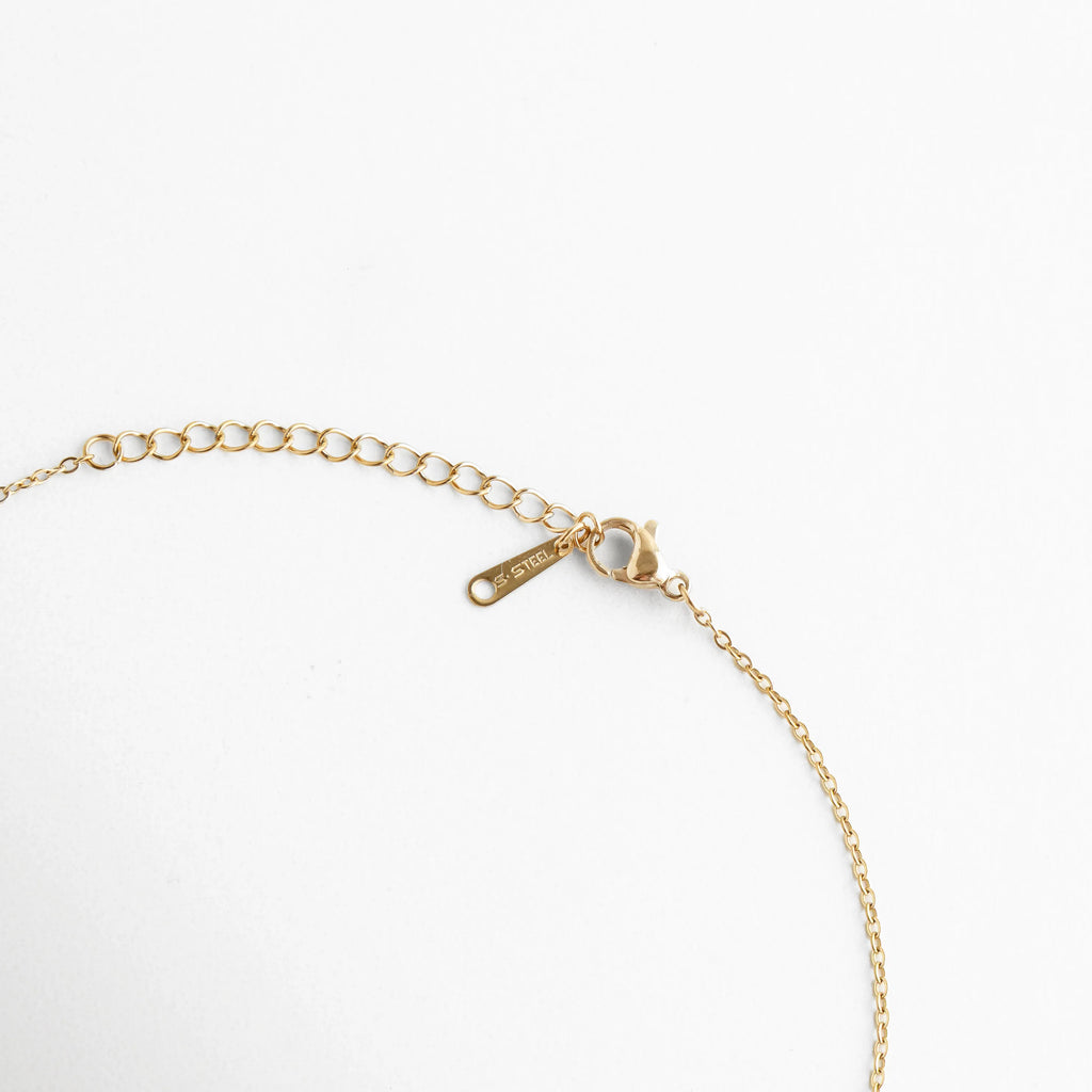 Vista del broche tipo langosta y la cadena de extensión ajustable en acabado dorado, Detalle técnico del sistema de cierre seguro para el collar de elefante de jade, Terminación de la cadena con eslabones de ajuste para diferentes alturas de escote, Cierre de joyería fina resaltando el pulido del baño de oro y la placa de calidad, Muestra del extensor de cadena para personalizar el largo del collar de amuleto.