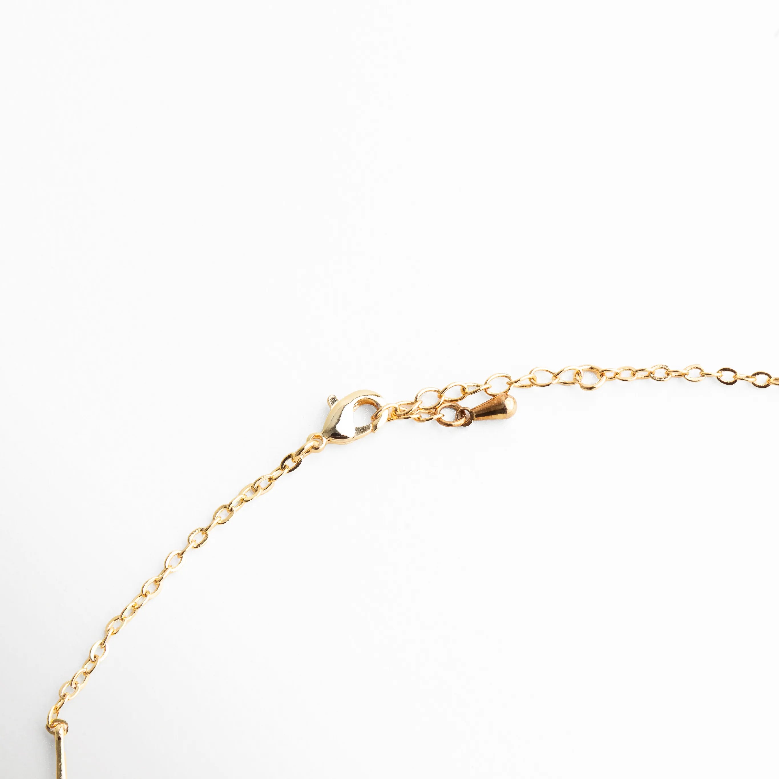 Detalle del broche y cadena ajustable del collar dorado con acabado fino y delicado.