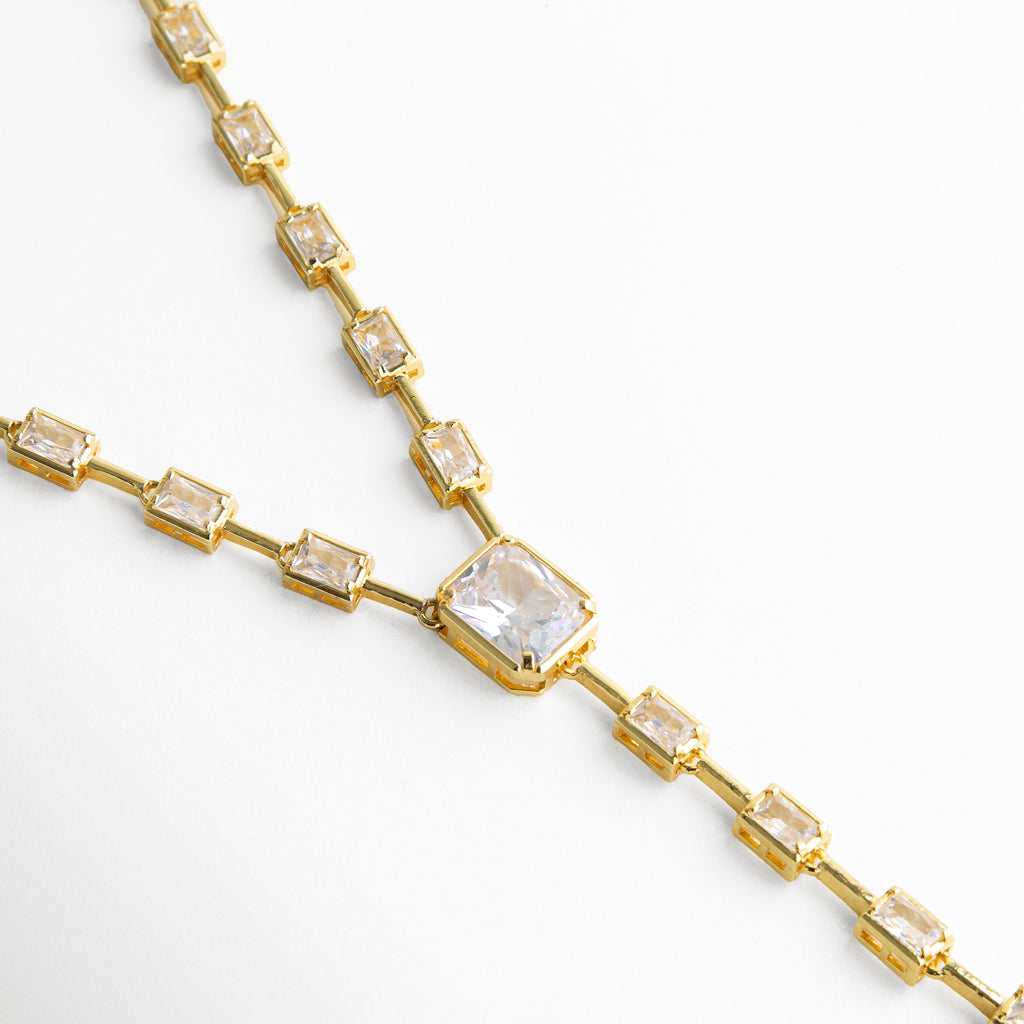 Detalle del centro del collar lariat dorado con eslabón protagonista y diseño minimalista.