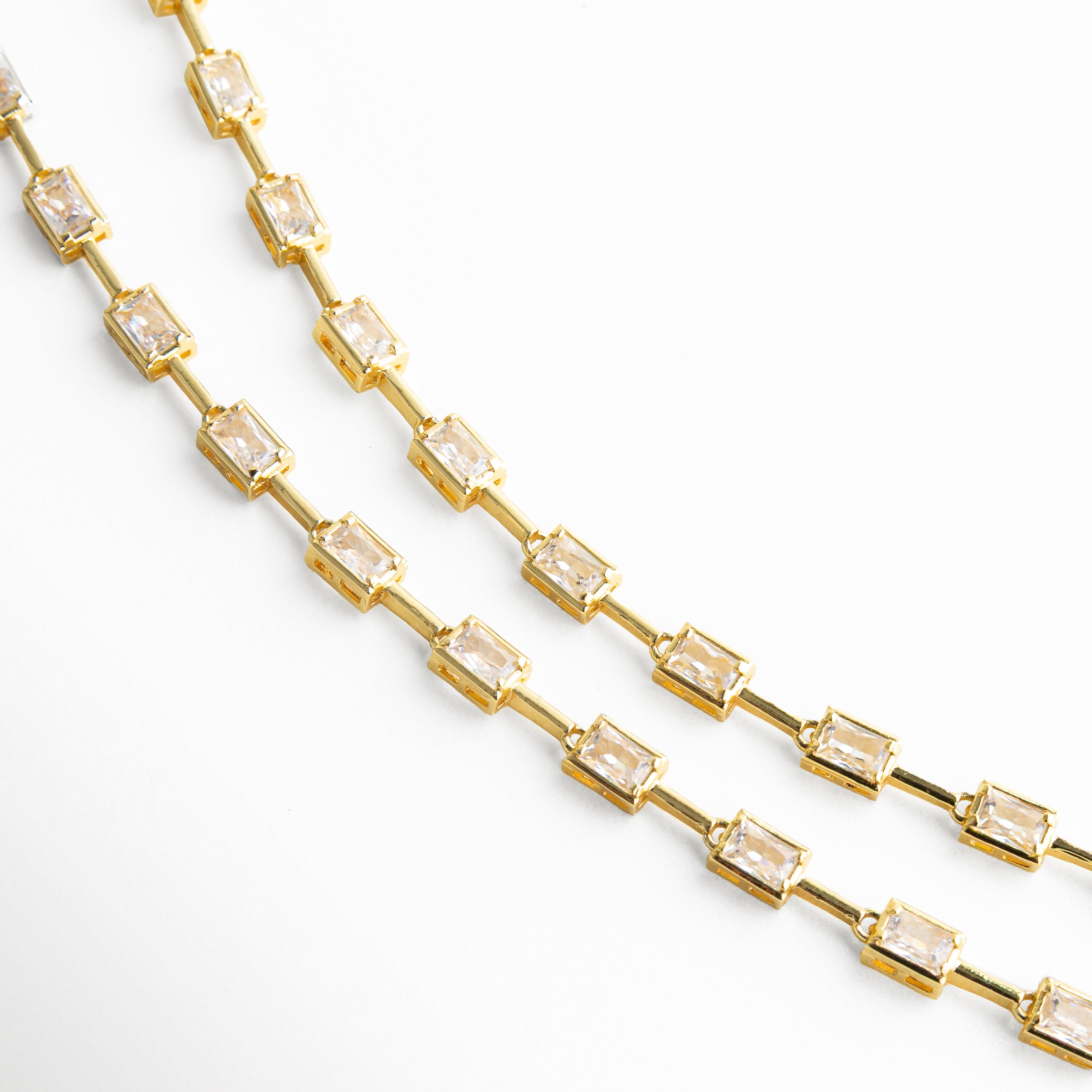 Detalle de eslabones rectangulares del collar lariat dorado con diseño moderno y sofisticado.