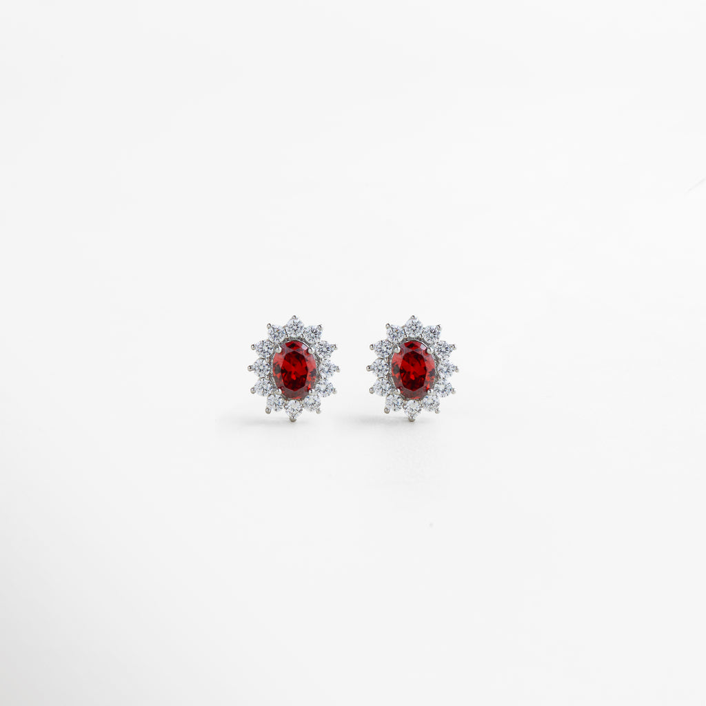 Aretes plateados con cristal rubí en centro y halo de zirconias, diseño romántico y con carácter, joyería sofisticada para dar un toque apasionado a cualquier look