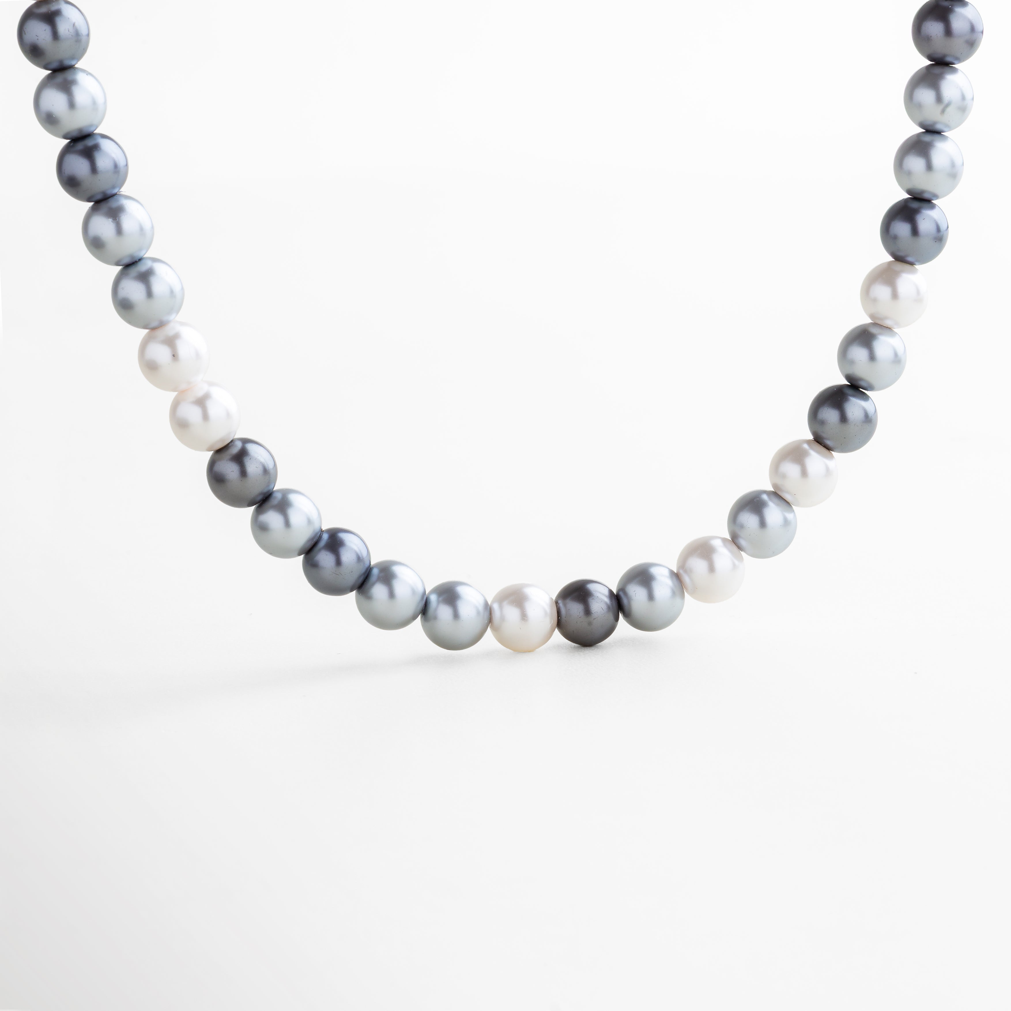 Collar Jolette Black Pearl visto de frente, con perlas negras uniformes y acabado brillante sobre cadena de 43 cm. Vista frontal del collar de perlas negras, con diseño clásico renovado y presencia sofisticada. Collar de perlas negras con forma redondeada y alineación continua visto desde el frente. Primer plano frontal del collar de conchas negras, destacando su estilo elegante y moderno. Collar con perlas de agua dulce en tono negro, con brillo sutil y diseño atemporal visto de frente.