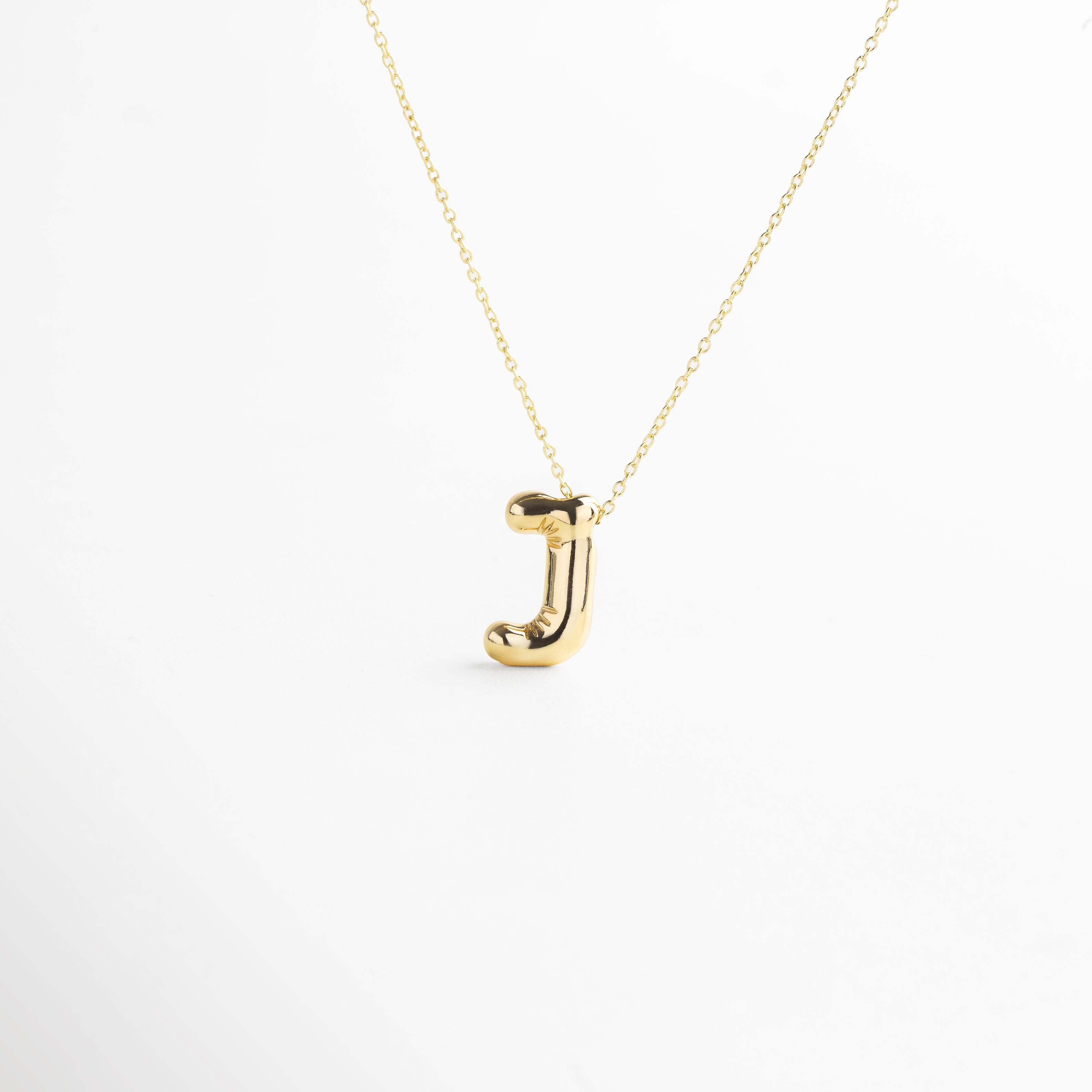 Collar dorado de inicial J con diseño bold y moderno, Inicial J grande en chapa de oro 18K con acabado brillante, Pieza personalizable con significado y estilo atemporal, Letra J central como protagonista del diseño sofisticado, Diseño de cadena fina con punto focal en forma de J