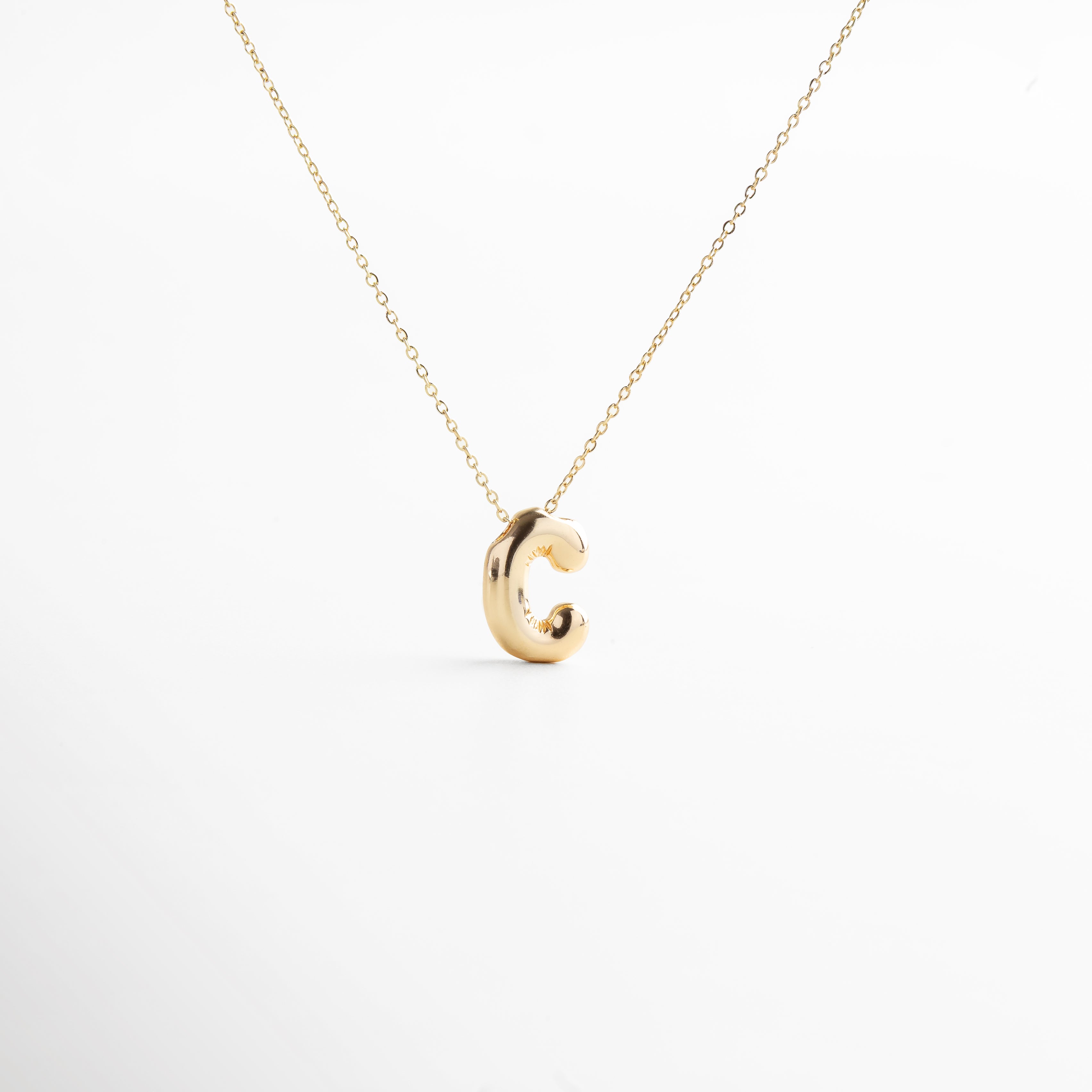 Collar dorado de inicial C con diseño bold y moderno, Inicial C grande en chapa de oro 18K con acabado brillante, Pieza personalizable con significado y estilo atemporal, Letra C central como protagonista del diseño sofisticado, Diseño de cadena fina con punto focal en forma de C