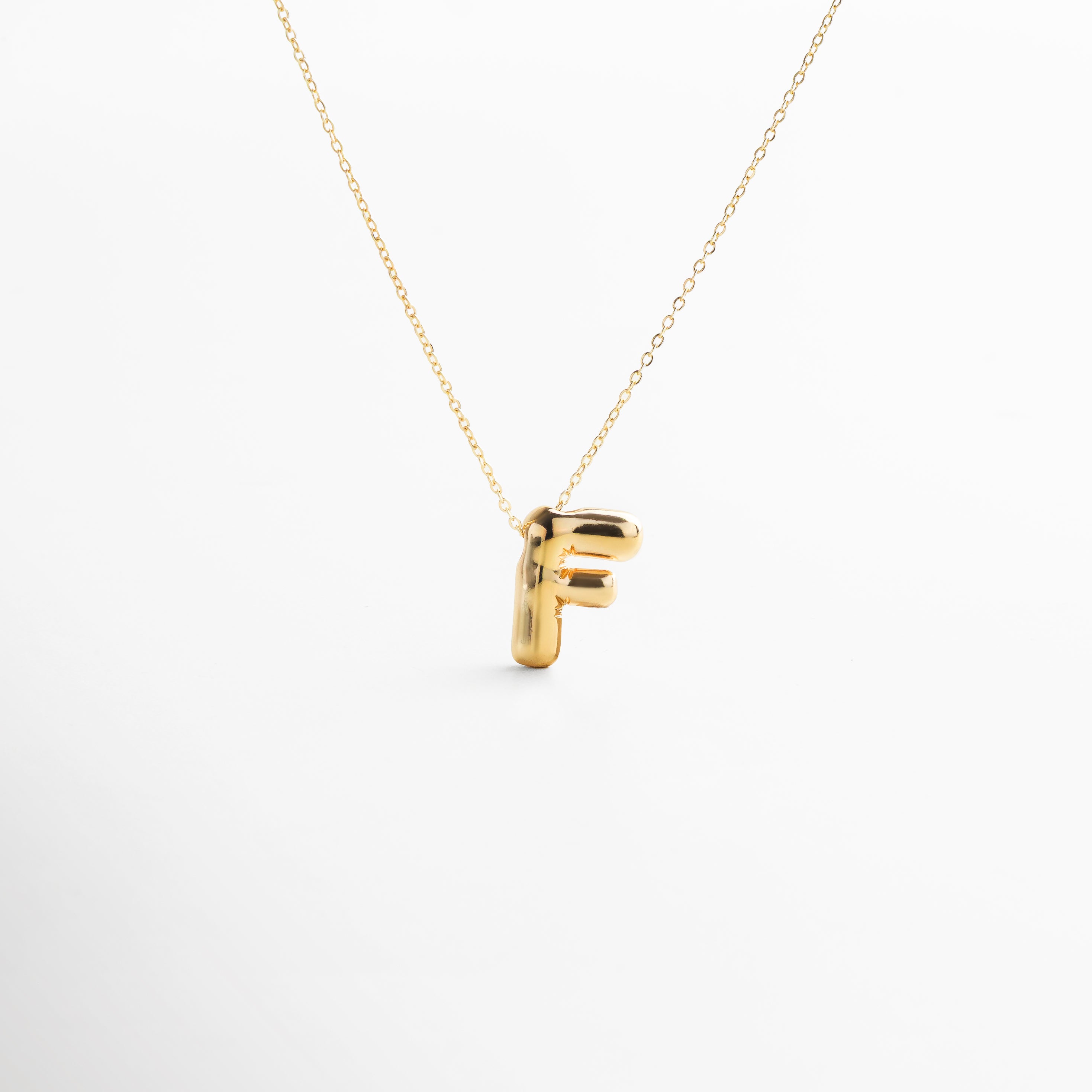 Collar dorado de inicial F con diseño bold y moderno, Inicial F grande en chapa de oro 18K con acabado brillante, Pieza personalizable con significado y estilo atemporal, Letra F central como protagonista del diseño sofisticado, Diseño de cadena fina con punto focal en forma de F