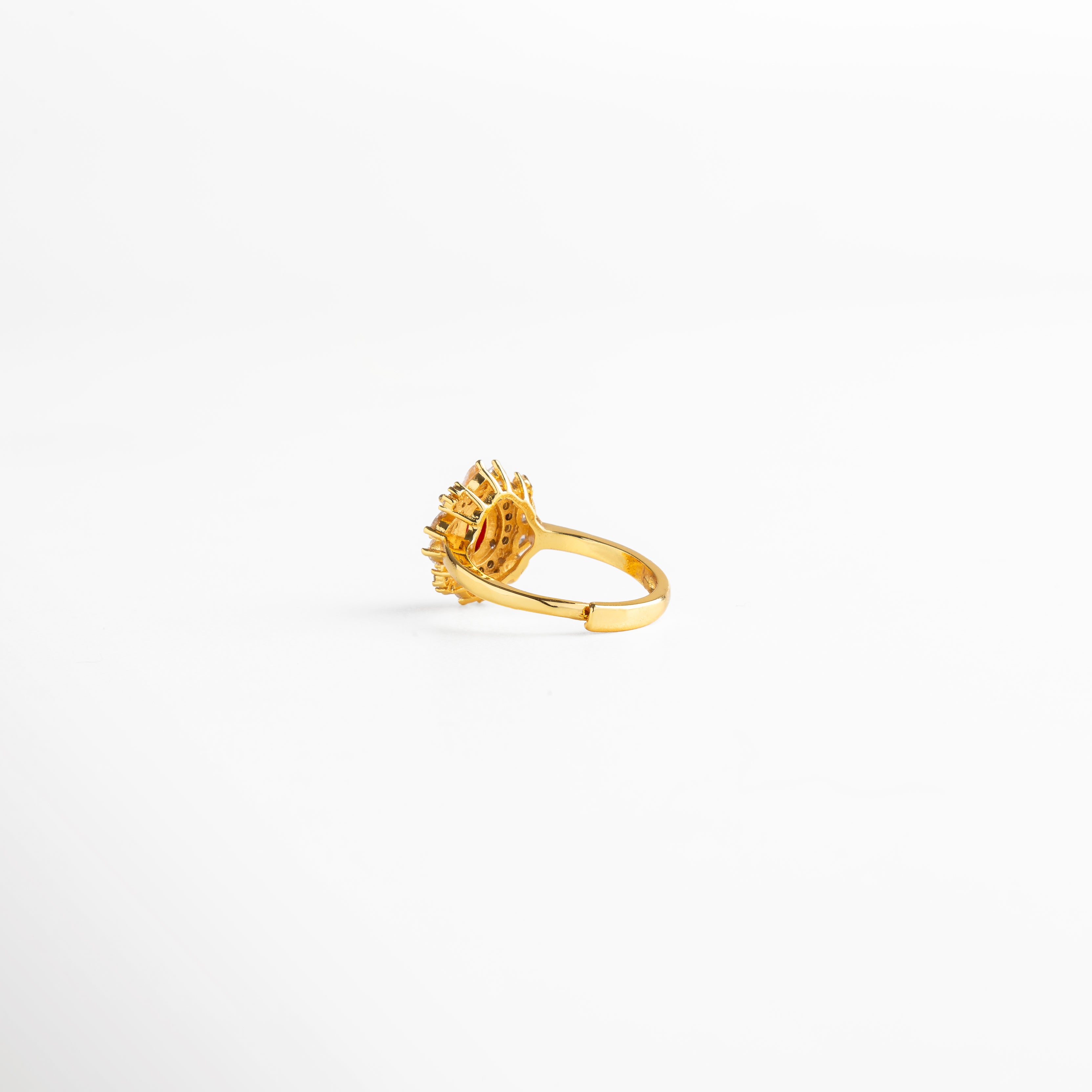 Vista posterior del anillo ajustable en cobre con recubrimiento de oro 18K, detalle de la base abierta y engaste de piedra central roja con zirconias incrustadas, diseño resistente y elegante con acabado pulido y estilo atemporal.
