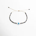 Pulsera negra con cuentas de vidrio y dije central de ojo turco azul, protección y estilo, Pulsera ajustable de hilo beige con cuentas negras y ojo turco, amuleto contra malas energías, Pulsera artesanal negra con ojo turco, joyería moderna de protección y moda.
