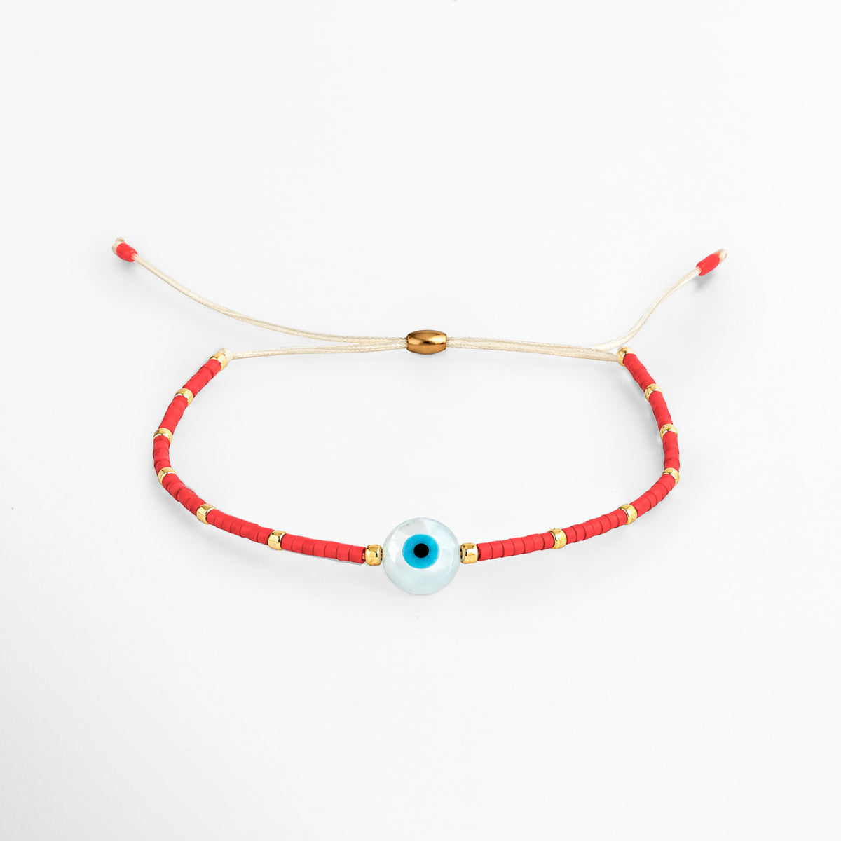 Pulsera Roja Ojo Turco ajustable tejida en hilo natural beige con discos de cerámica roja, balines dorados y dije central de ojo turco azul y blanco, vista frontal sobre fondo blanco, Vista de frente de pulsera amuleto con hilo rojo y beige, cuentas de cerámica y dije esférico de ojo turco central protector, Plano general de pulsera protectora de hilo natural con discos de cerámica roja y acentos dorados sobre fondo neutro, Pulsera Roja Ojo Turco