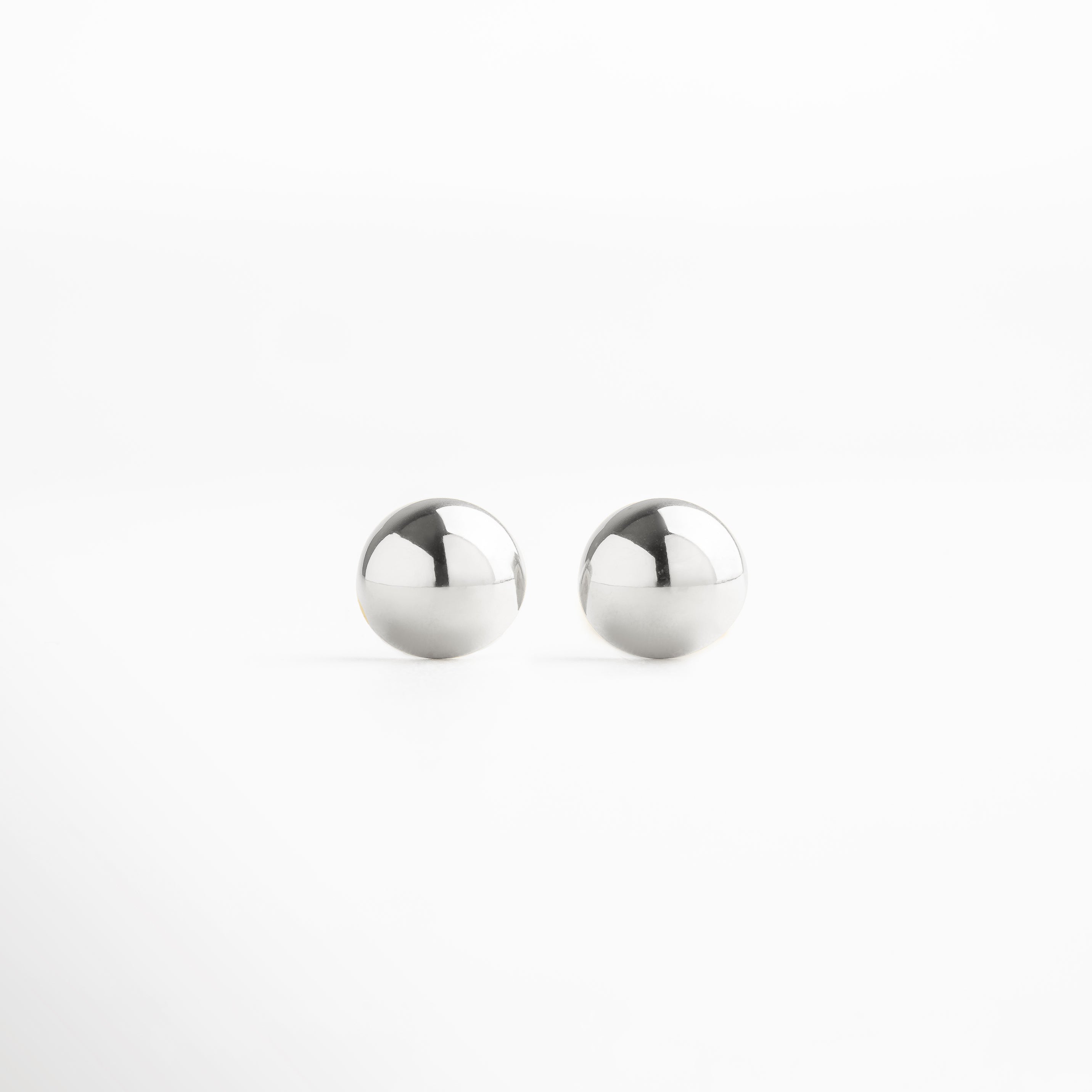 Aretes de botón esféricos plateados de acero inoxidable, diseño minimalista con acabado pulido espejo, ideales para un look elegante y atemporal.