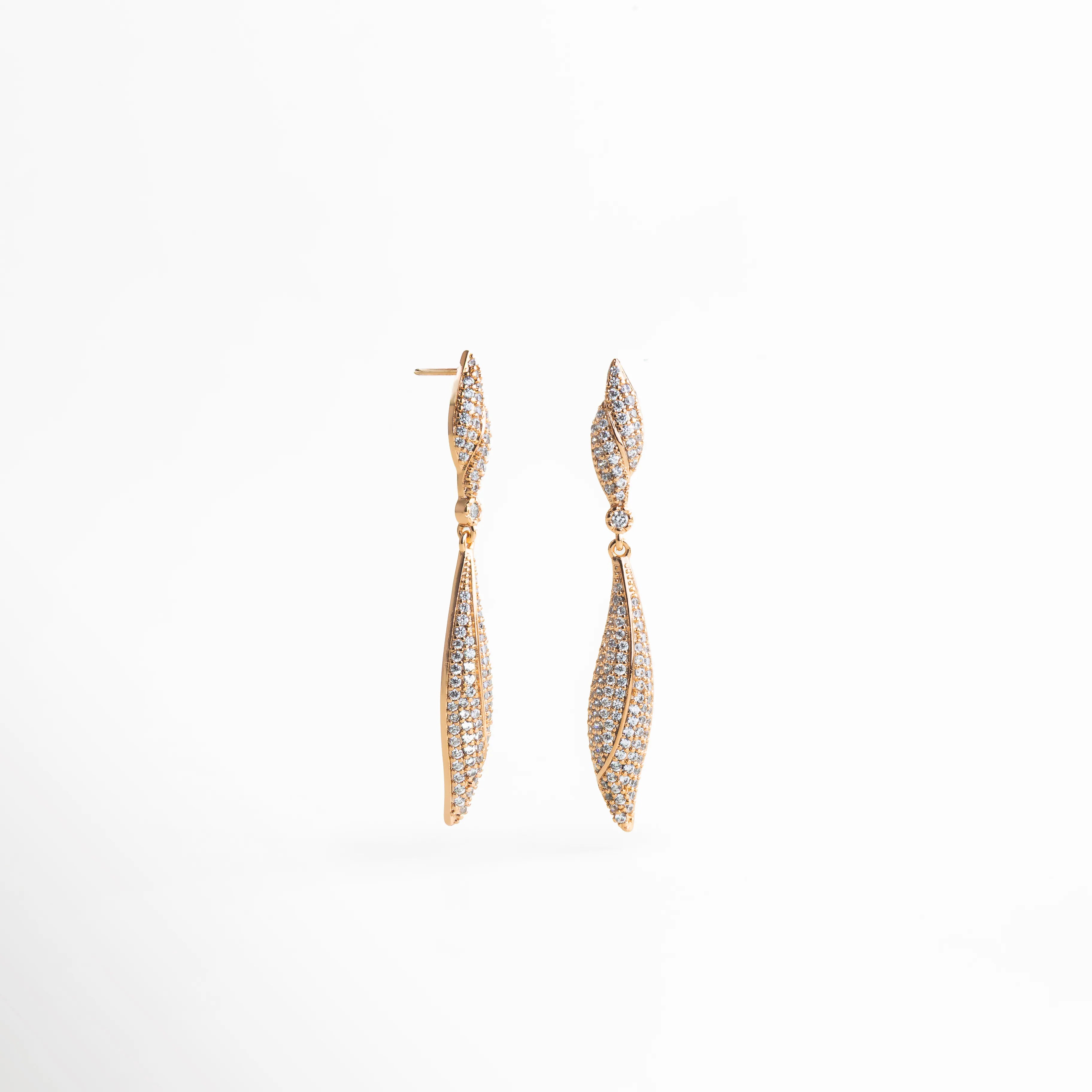 aretes largos dorados con zirconias corte hoja, vista lateral mostrando perfil y caída del diseño, fondo blanco, accesorio glamuroso para noche y looks de impacto