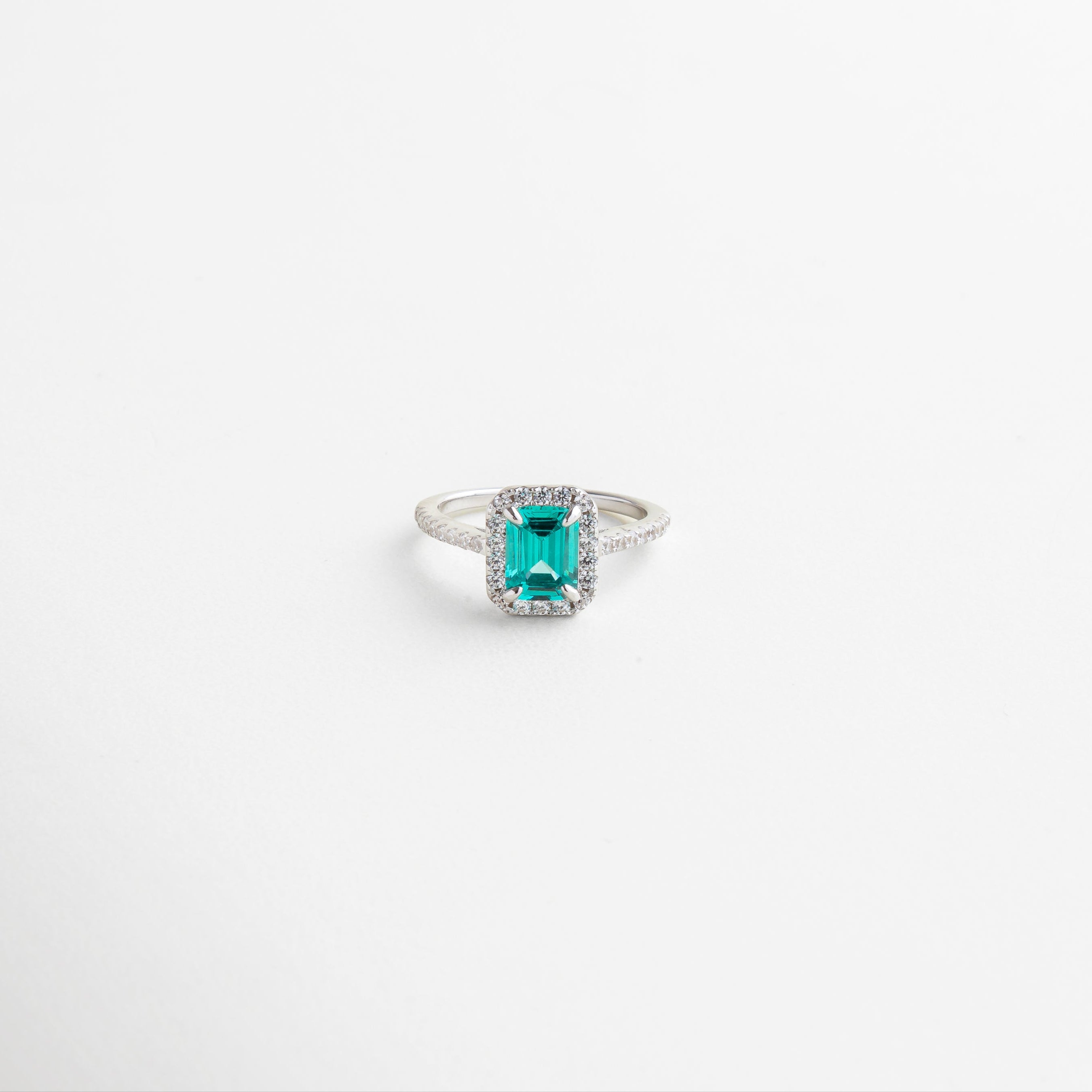 Anillo con piedra azul intenso y halo de zirconias brillantes, Joya de plata 925 enchapada en oro blanco 18K, Diseño elegante con aura de misterio y sofisticación, Anillo de cóctel con piedra central rectangular azul, Accesorio refinado ideal para eventos especiales