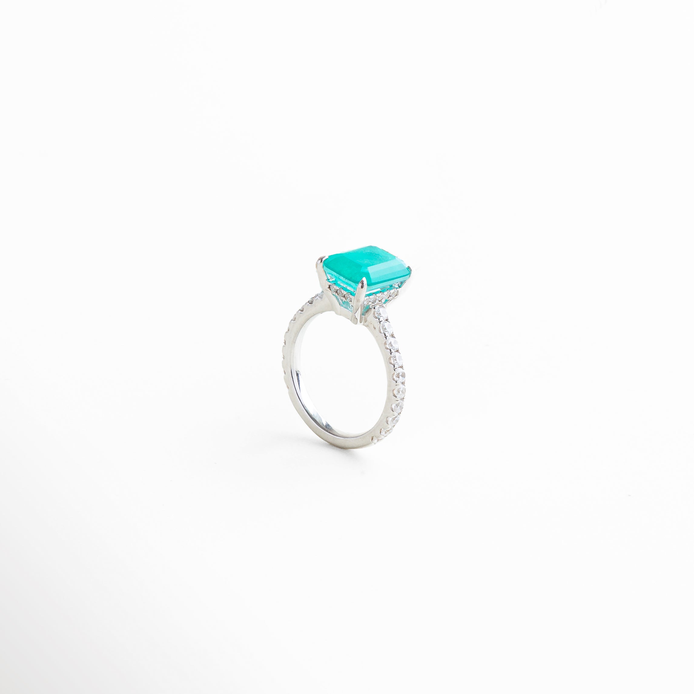 Primer plano del anillo mostrando el brillo del diamante Turmalina de Paraíba y las piedras preciosas, resaltando la calidad del acabado en oro blanco y la delicadeza del diseño