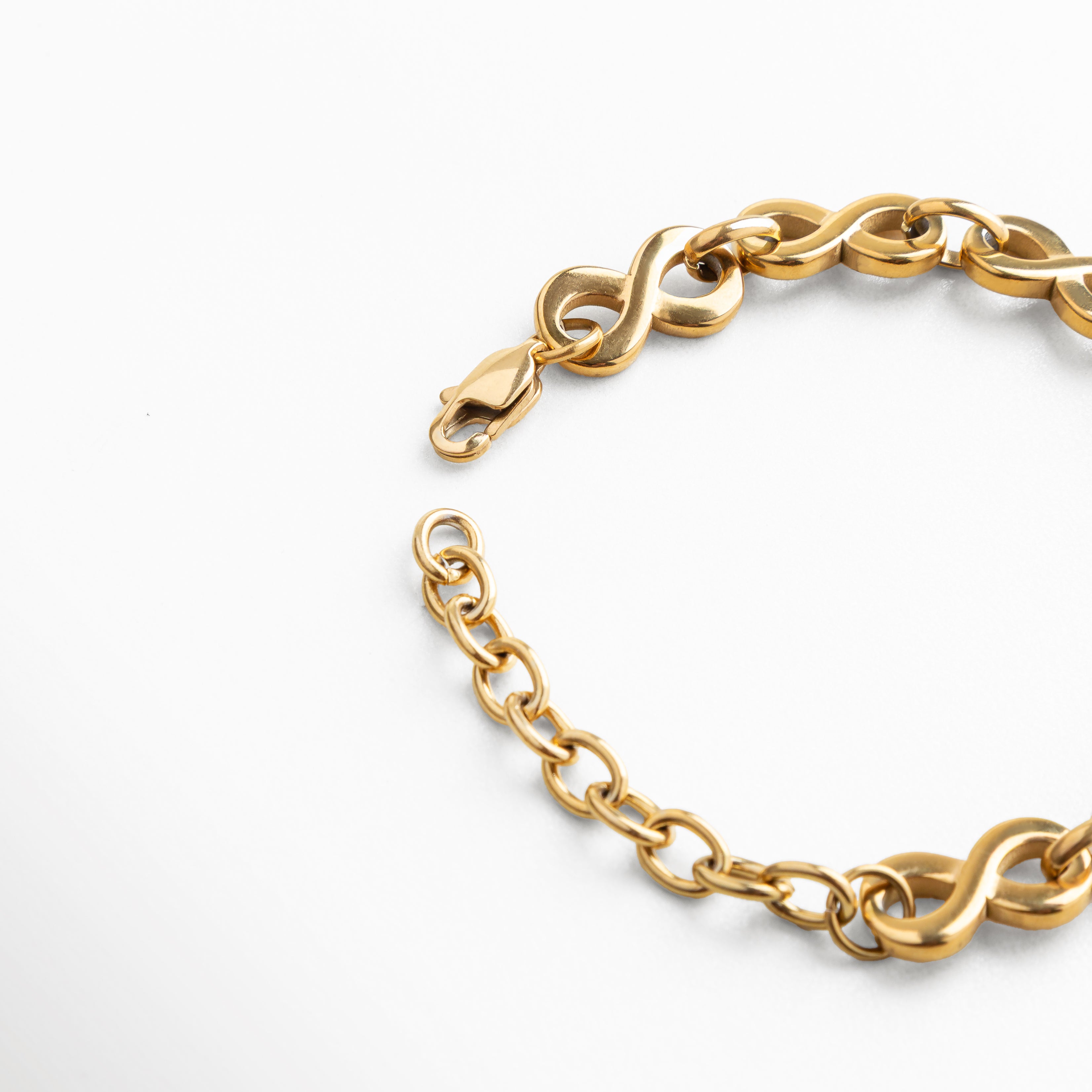 Pulsera de acero inoxidable recubierta en oro 18K, vista del broche con extensión ajustable de 15 + 5 cm, eslabones entrelazados de acabado pulido que reflejan un diseño versátil, elegante y lleno de carácter femenino.