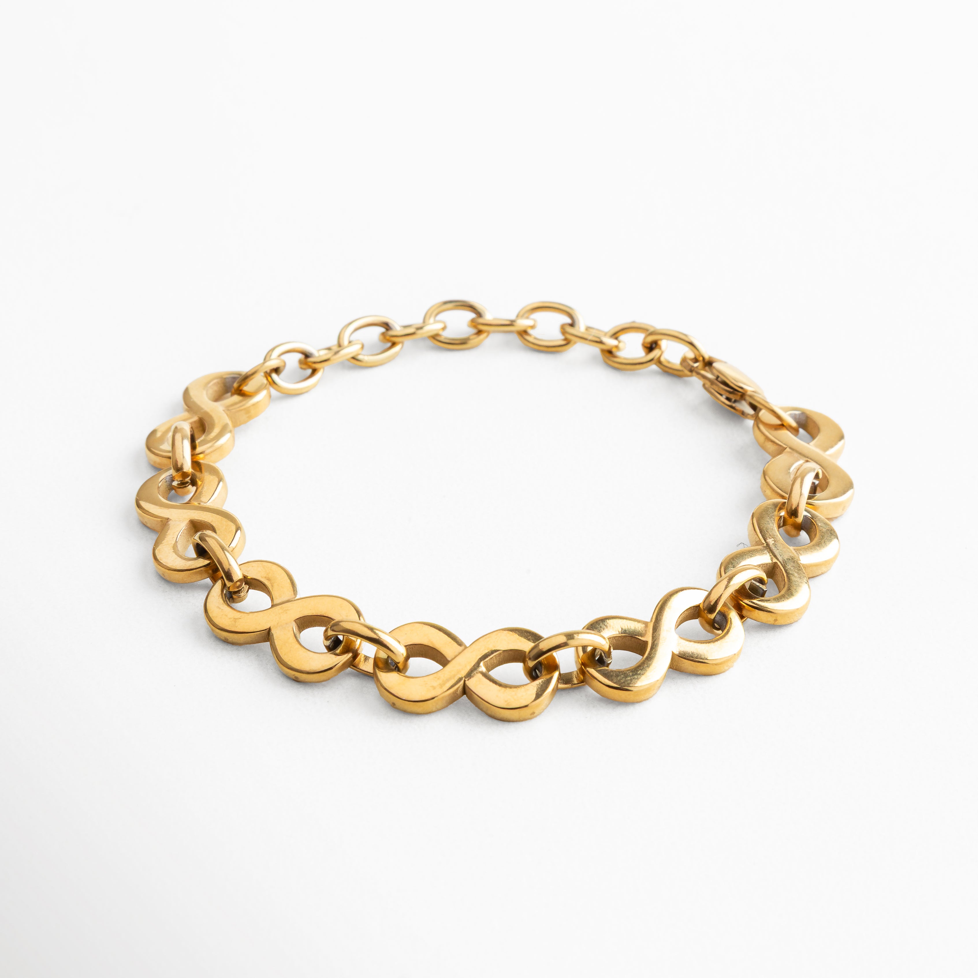 Pulsera de acero inoxidable con recubrimiento enchapado en oro 18K, diseño de eslabones entrelazados de 1 cm de ancho, longitud ajustable de 15 + 5 cm, joya elegante y moderna que refleja fuerza y feminidad en su estilo.
