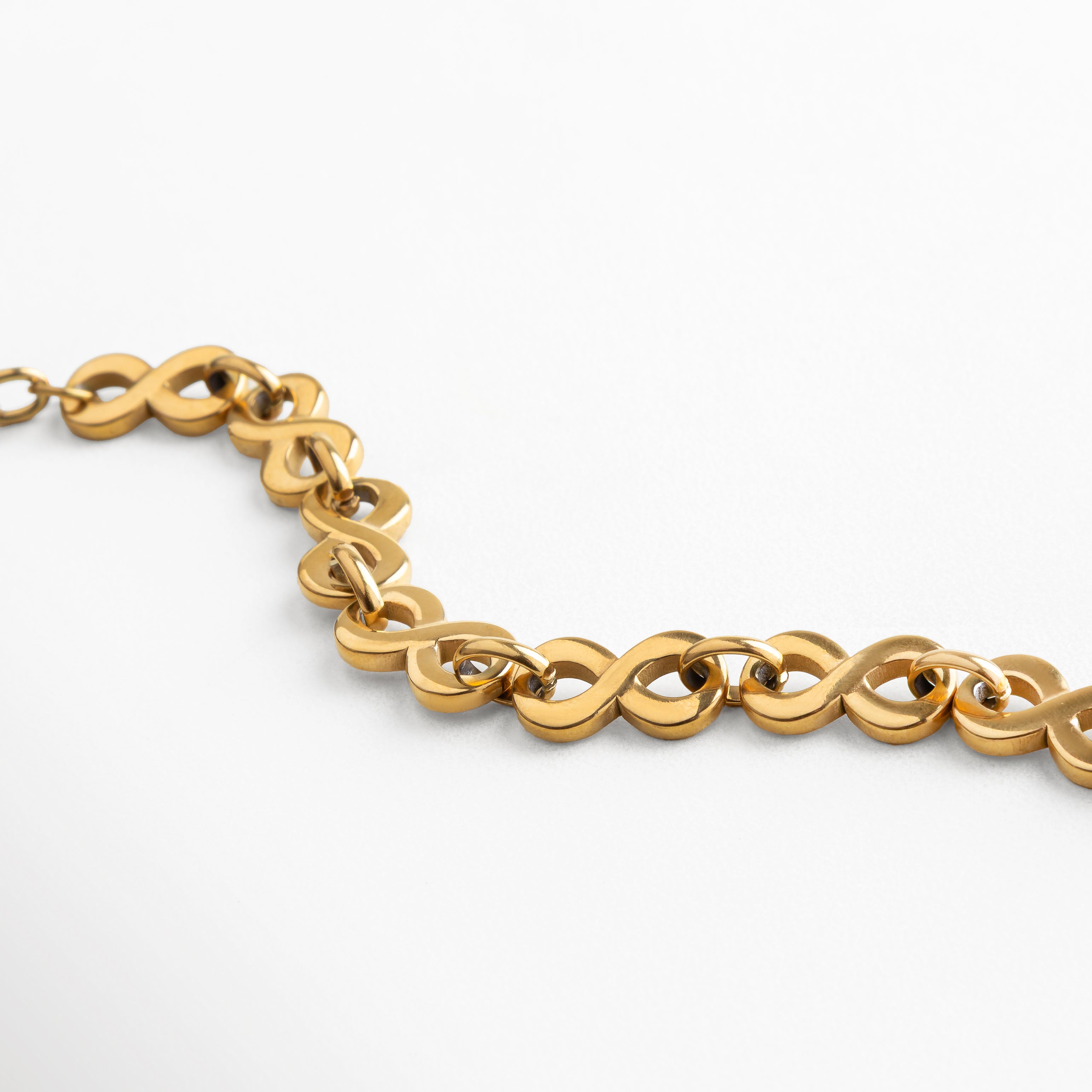 Detalle cercano de la pulsera de acero inoxidable con baño de oro 18K, mostrando eslabones entrelazados de acabado brillante, diseño de 1 cm de ancho que combina carácter y elegancia en un accesorio femenino y sofisticado.