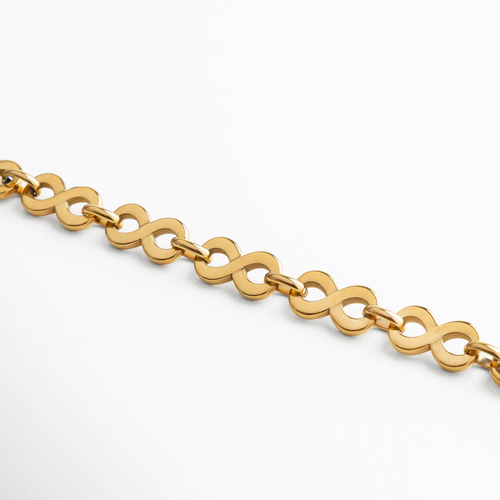 Vista extendida de la pulsera de acero inoxidable bañada en oro 18K, con diseño de eslabones entrelazados en forma orgánica, acabado pulido brillante y estilo versátil, pieza contemporánea que combina simplicidad e impacto visual.
