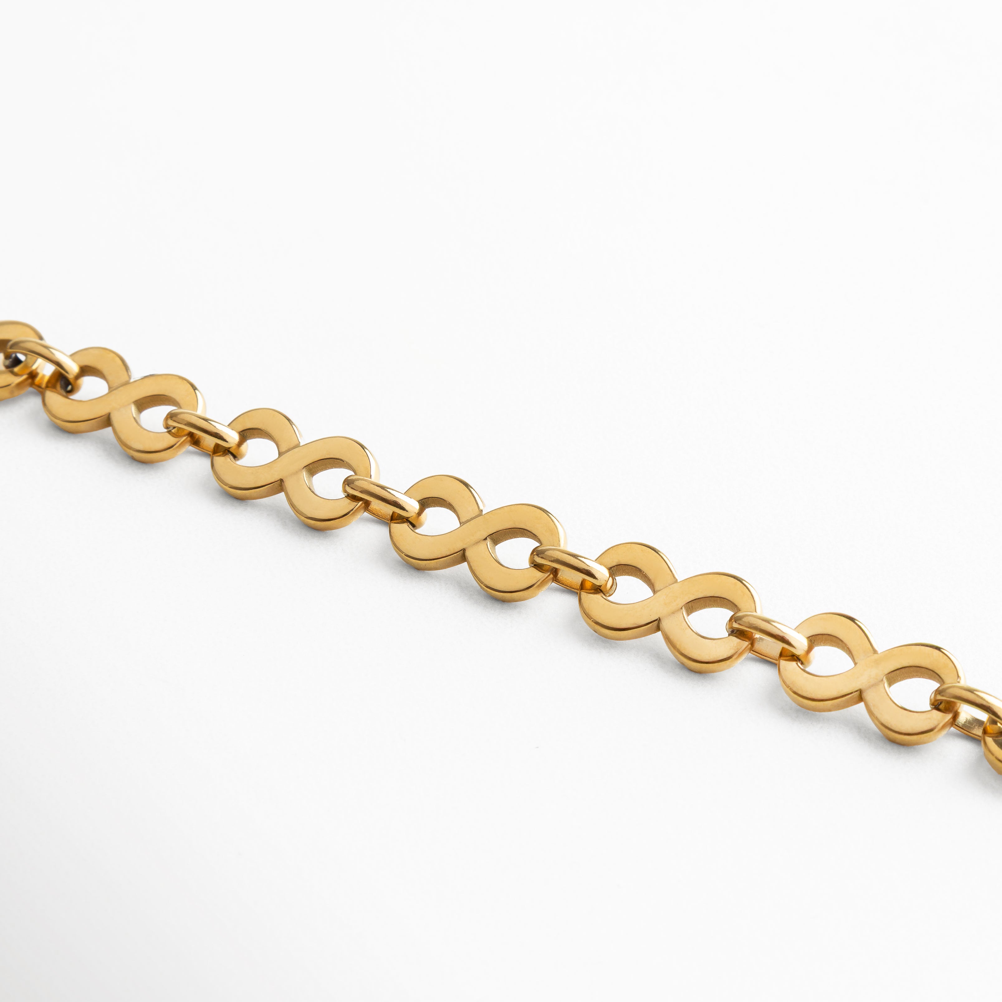 Vista extendida de la pulsera de acero inoxidable bañada en oro 18K, con diseño de eslabones entrelazados en forma orgánica, acabado pulido brillante y estilo versátil, pieza contemporánea que combina simplicidad e impacto visual.