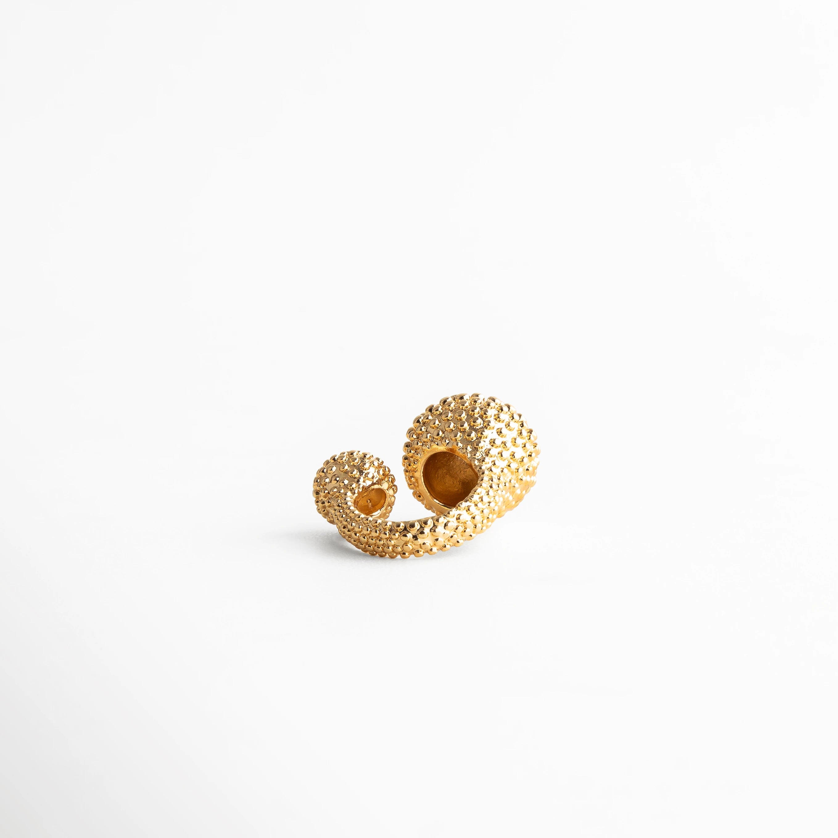 Anillo dorado abierto con textura de burbujas, diseño artístico y moderno con detalles únicos, joya minimalista y llamativa.