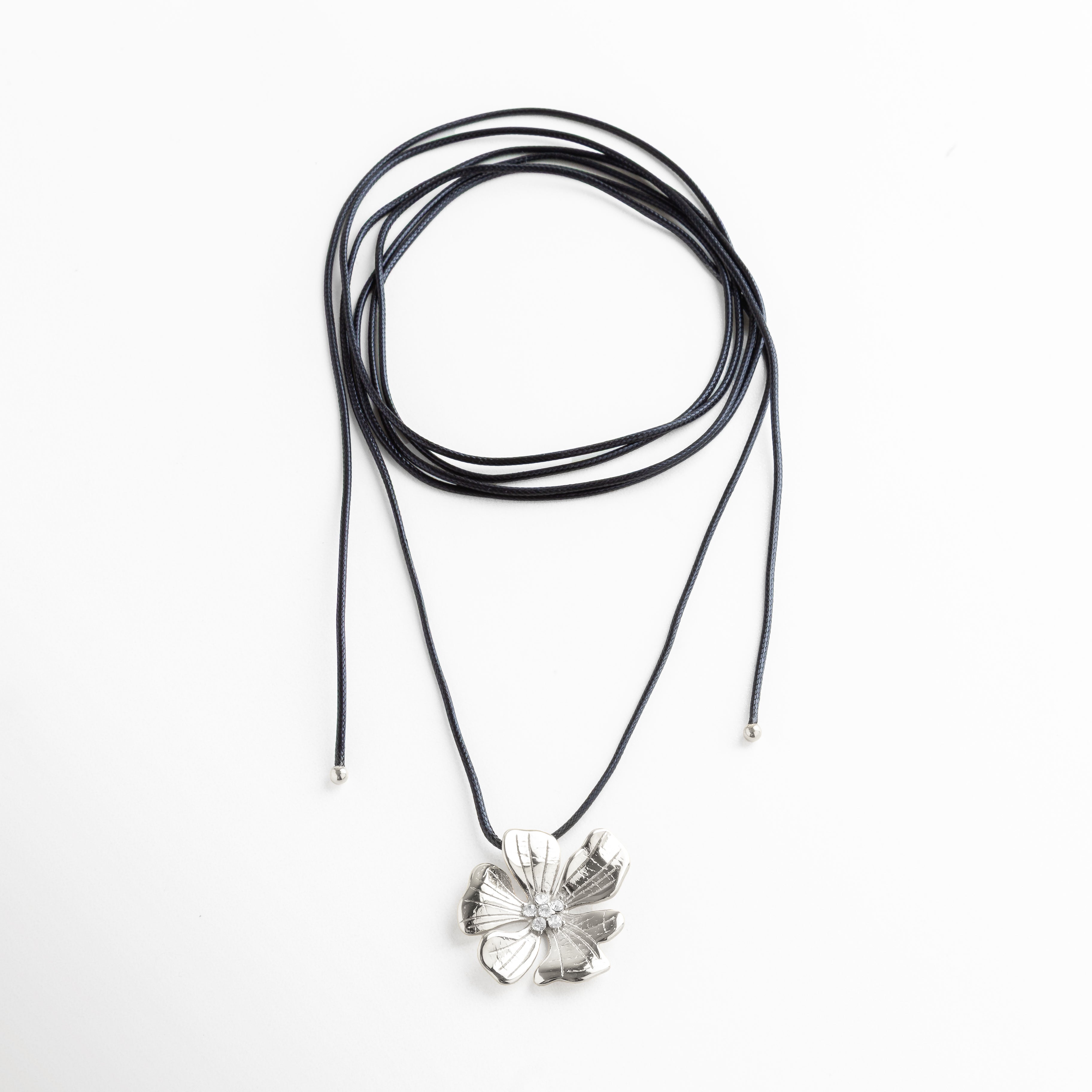 Collar plateado con flor de pétalos amplios y cordón largo ajustable, diseño ligero y elegante con acabado brillante, ideal para quienes buscan un accesorio moderno con estilo artesanal y femenino