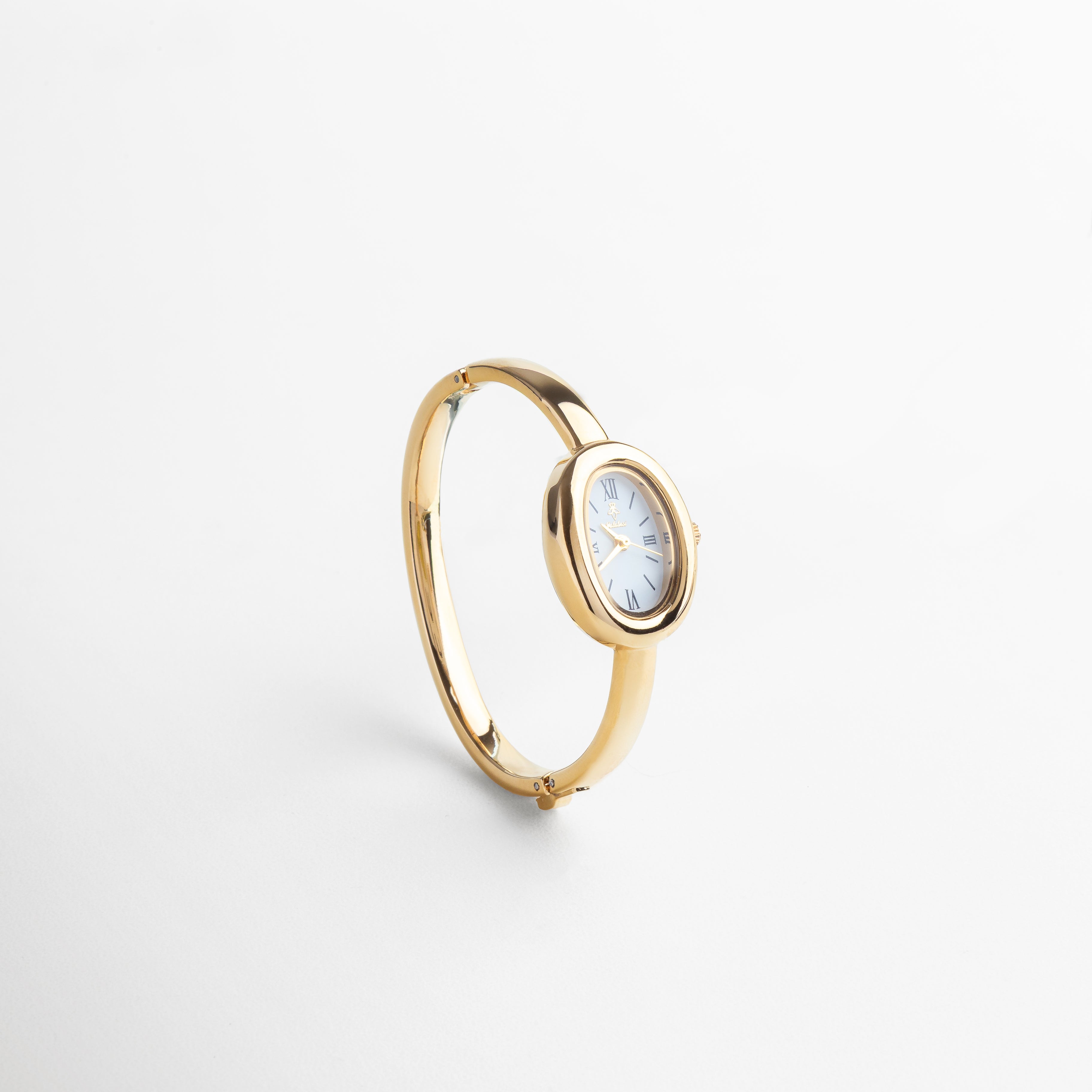 Reloj Braccialetto dorado visto desde el frente, con diseño tipo brazalete y esfera redonda de 2 cm. Vista frontal del reloj dorado minimalista con brazalete rígido y caja pequeña y elegante. Primer plano del Reloj Braccialetto en acabado dorado, con vitrina simple y estructura delgada. Reloj tipo brazalete en tono dorado, diseño frontal que resalta su elegancia atemporal. Reloj Braccialetto de acero inoxidable dorado visto de frente, ideal para looks discretos y sofisticados