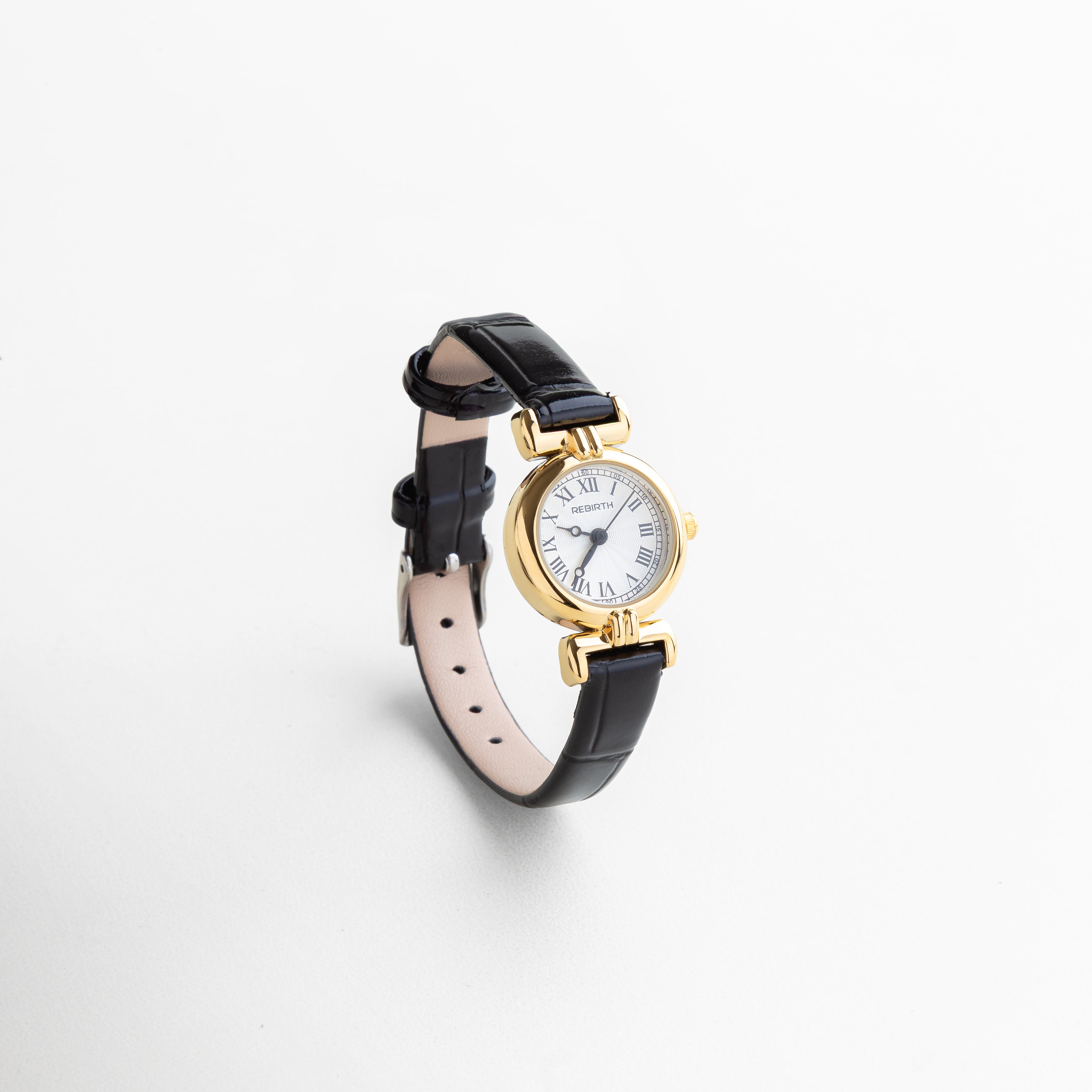 Reloj petite con correa negra y carátula dorada visto de frente, con diseño elegante y minimalista. Vista frontal del reloj femenino con vitrina circular de 2 cm y correa delgada en piel sintética. Reloj dorado con correa negra, diseño atemporal ideal para looks discretos y sofisticados. Primer plano del reloj en dorado y negro, con estilo clásico y moderno a la vez. Reloj de 22 cm con caja dorada y correa negra, visto desde el frente sobre fondo neutro.