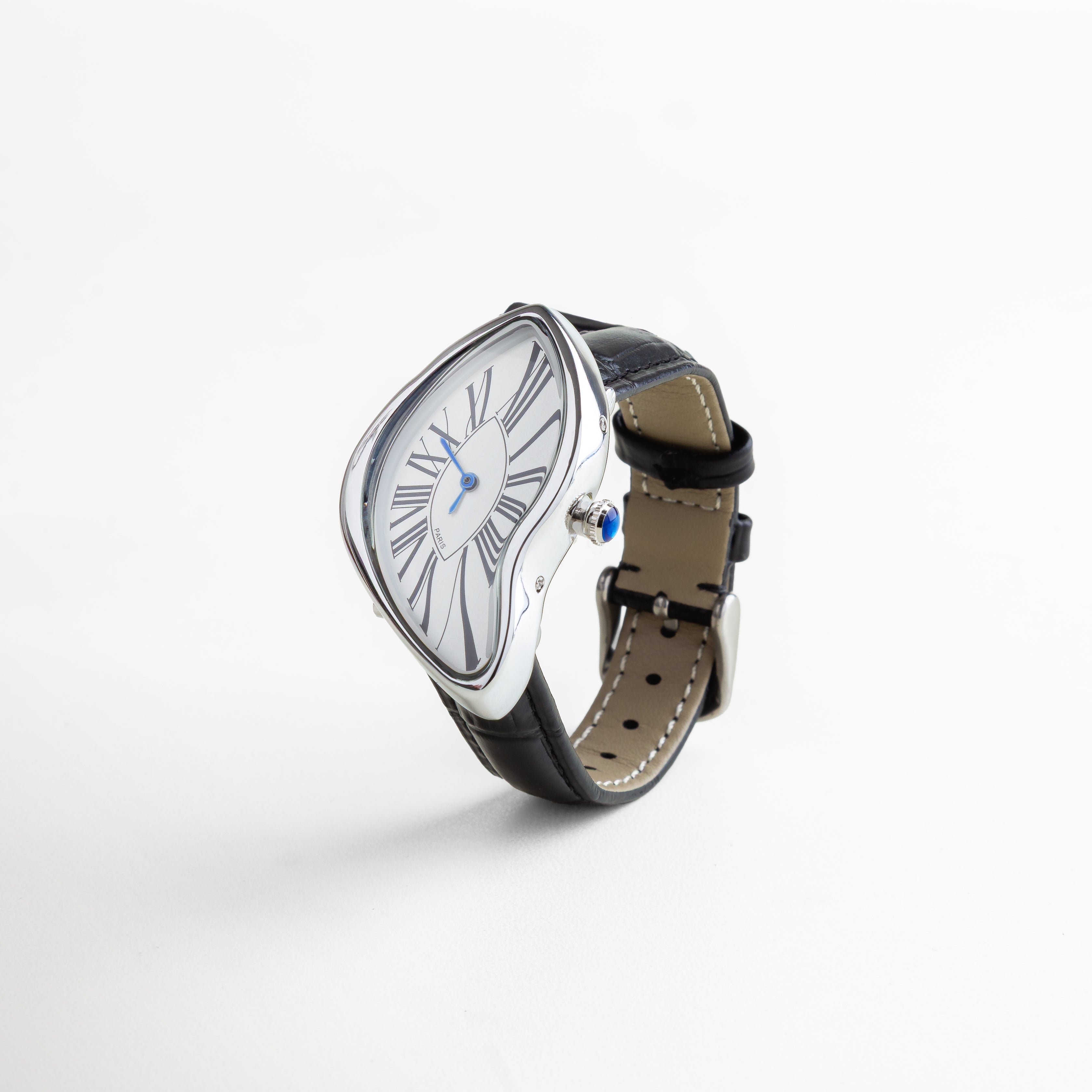 Reloj de acero de titanio con recubrimiento en oro 18K, dial blanco de 5 cm con números romanos en negro y manecillas azules, caja curvada de diseño artístico con correa negra en piel sintética, pieza llamativa y sofisticada.