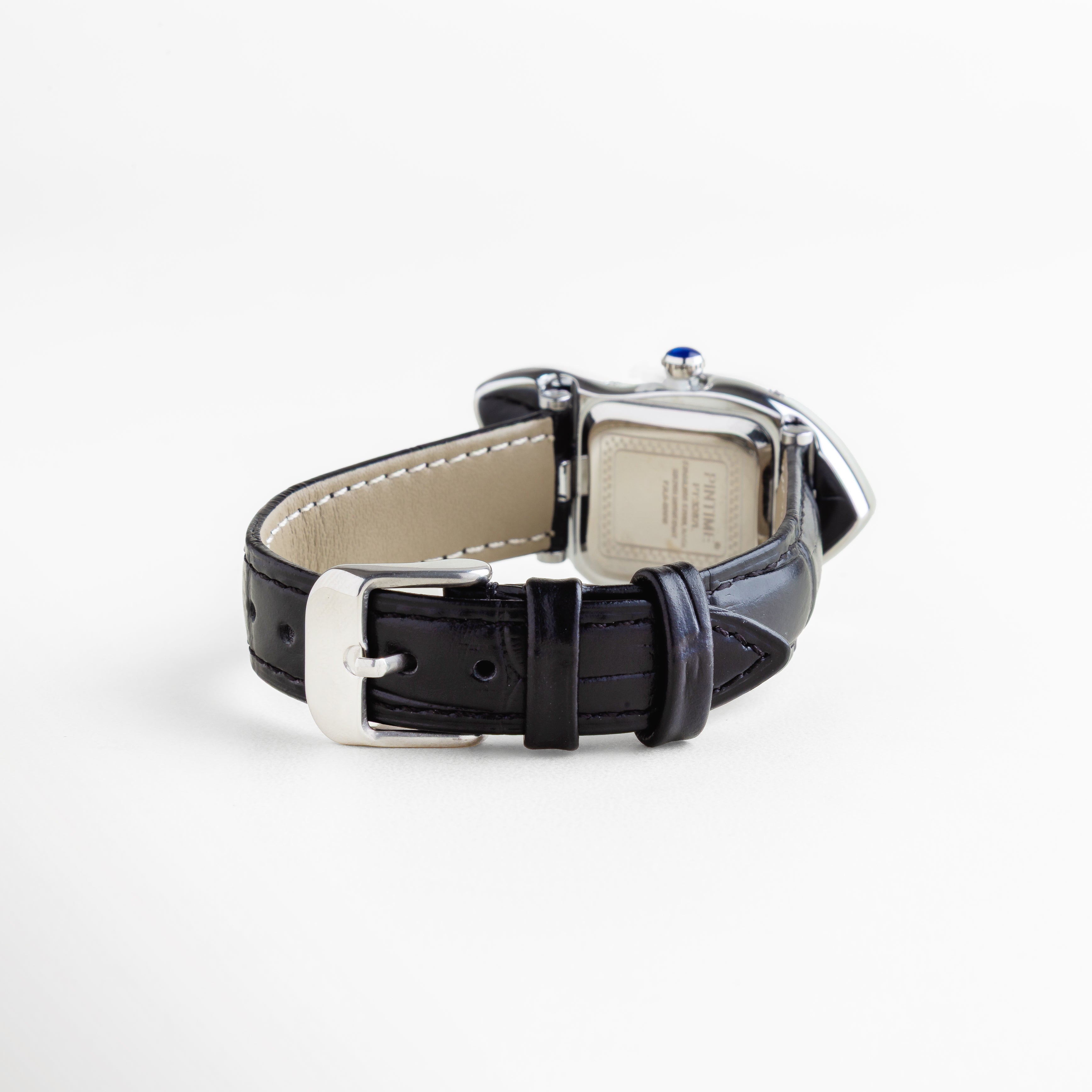 Vista posterior de reloj con caja metálica de titanio, correa negra de piel sintética con costuras visibles y hebilla de acero, diseño duradero y cómodo con acabado moderno y original que combina estilo clásico con un toque vanguardista.