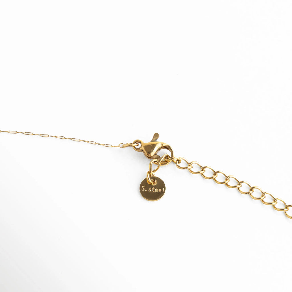 detalle de broche y extensión del collar de acero inoxidable dorado con dije de cuarzo rodocrosita, acabado pulido y cadena fina ajustable