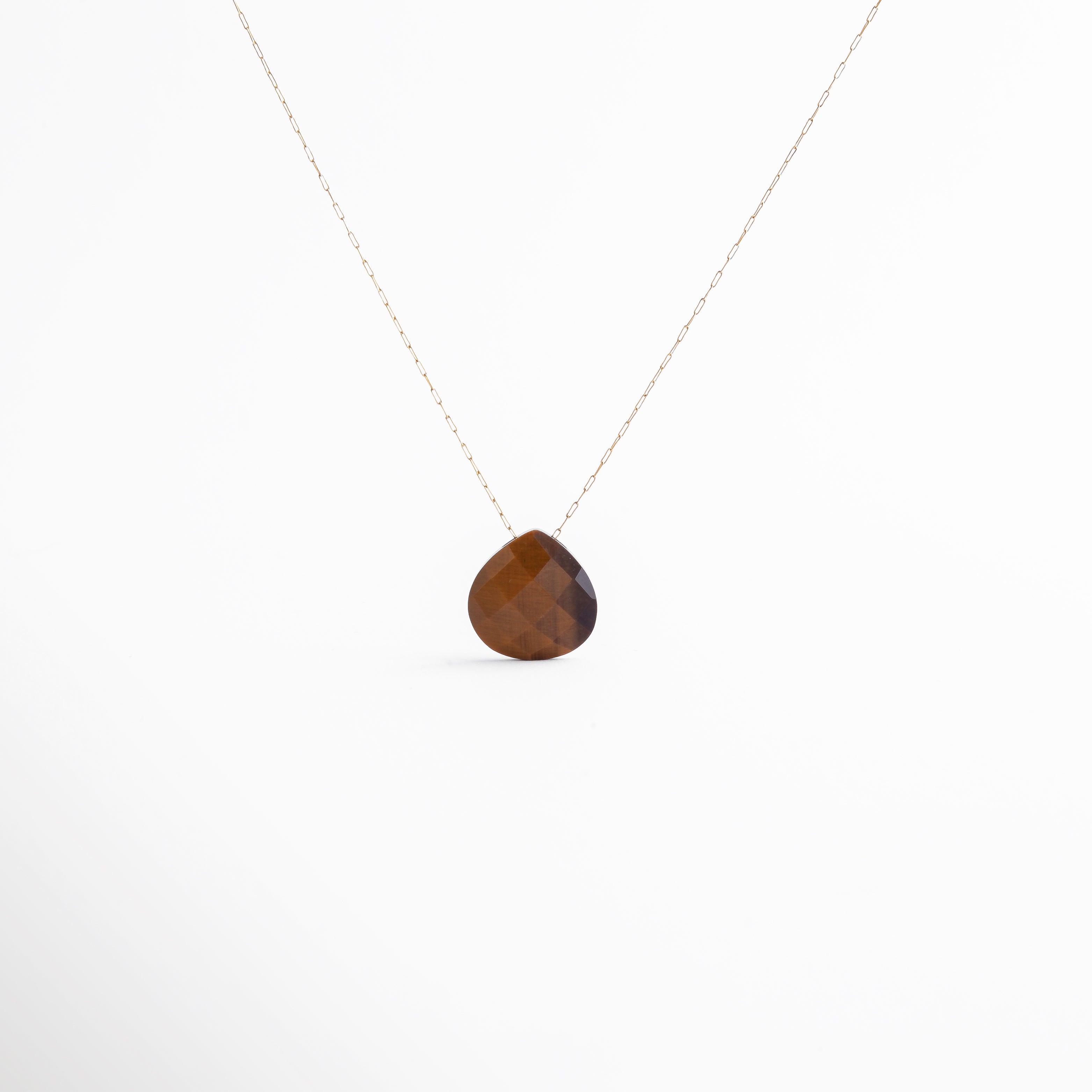 Collar con piedra natural ojo de tigre en corte gota, diseño minimalista y elegante. La cadena dorada resalta el tono cálido del cuarzo, perfecto para atraer fuerza y protección.